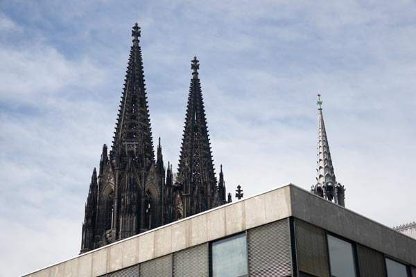 Cologne Cathedral spires above modern rooftop architecture