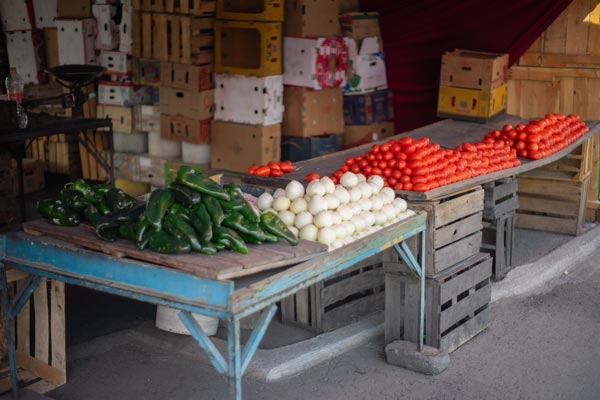 White onions at a rustic vegetable market stall