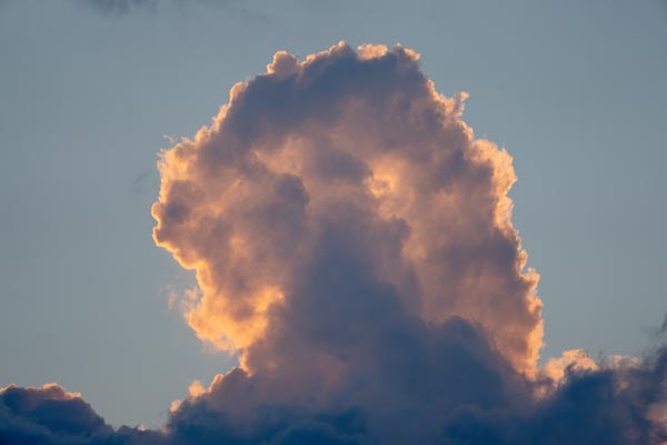 Leuchtende Quellwolke vor blauem Abendhimmel