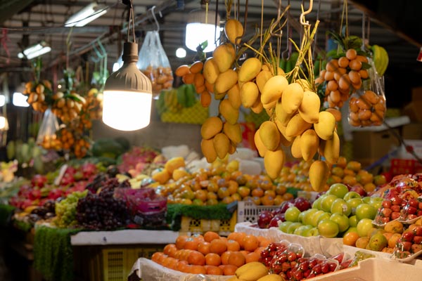 Reife Mangos an einem bunten Obstmarktstand