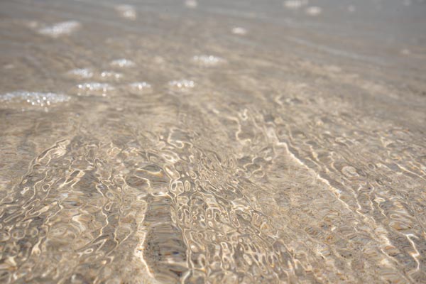 Sonnenreflexe auf flachem Wasser am Thung Wua Laen Beach