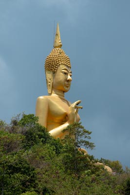 Goldene Buddhafigur auf bewachsenem Hügel in Chumphon