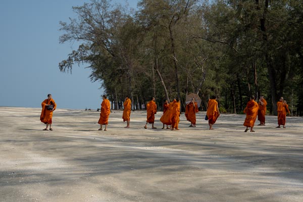 Buddhist monks walking along Laem Sala Beach