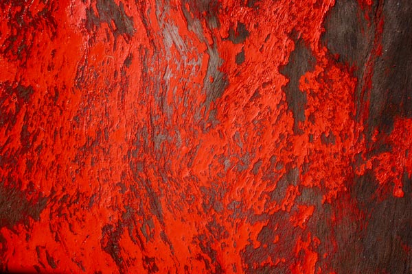 Peeling red paint on weathered wood