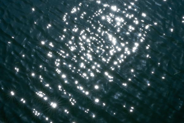 Sonnenlicht glitzert auf dunkelblauem bewegtem Wasser