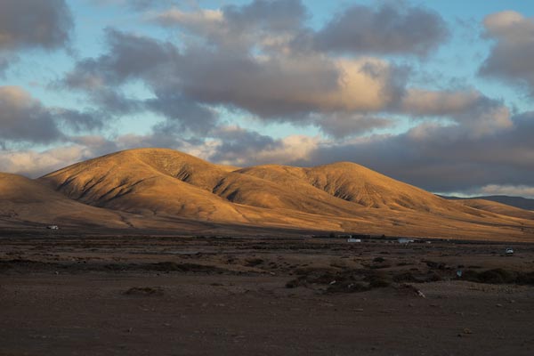 Golden hills beneath dramatic clouds