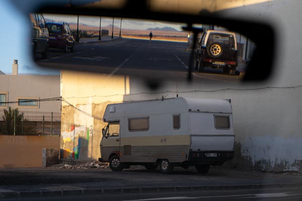 Wohnmobil vor verwitterter Hauswand mit Rückspiegelreflexion