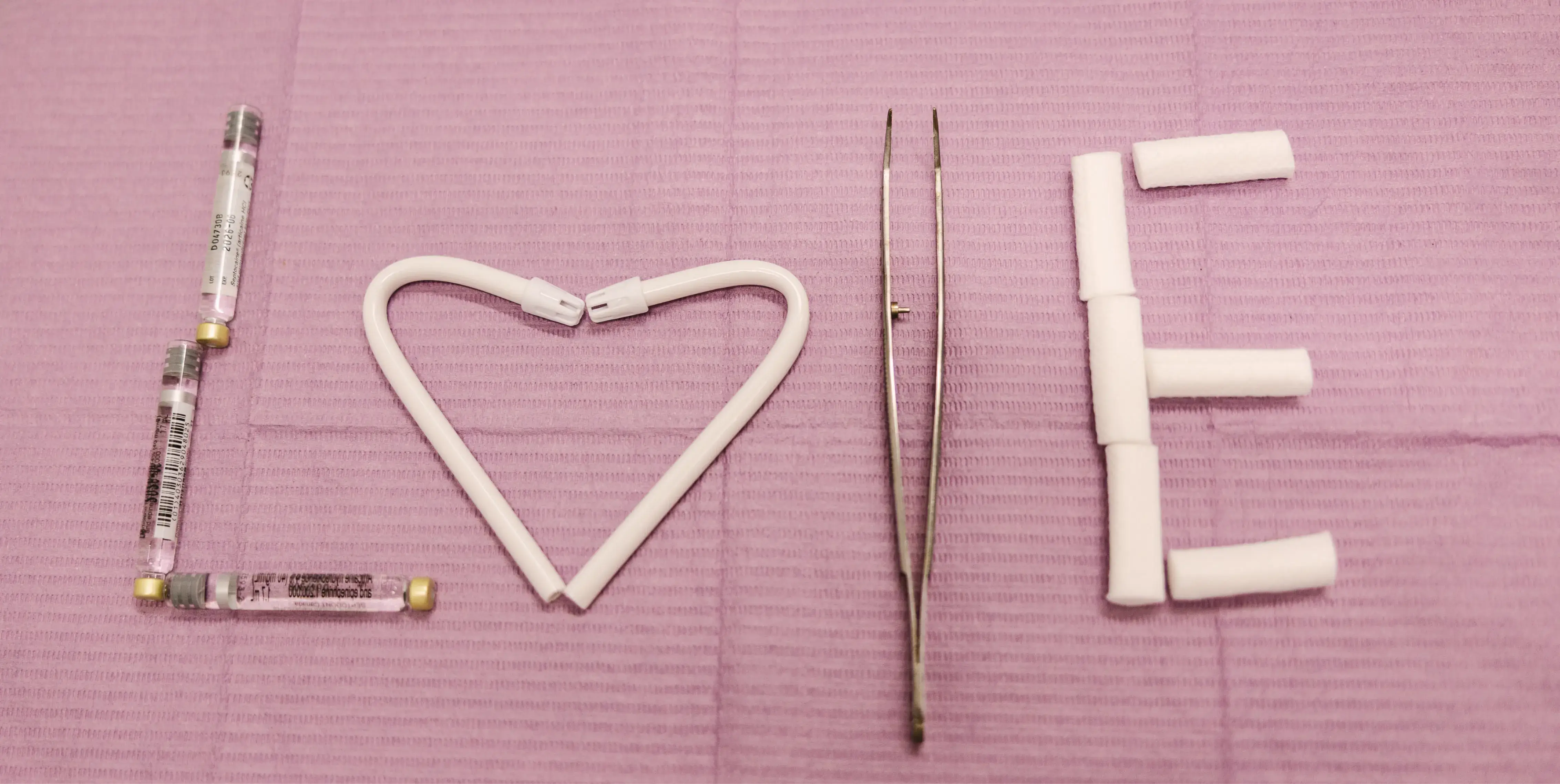 The word "LOVE" is creatively formed with dental tools on a purple background.