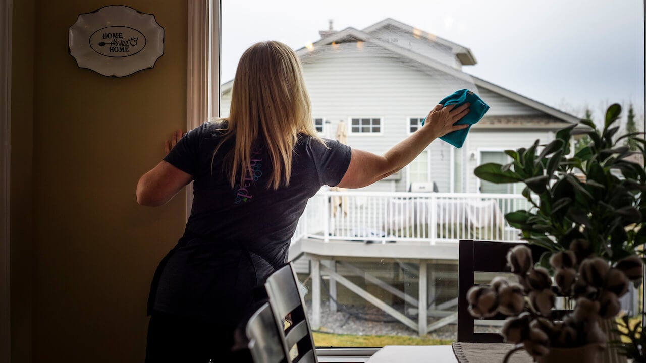 Maid performing home cleaning in Orchard Park NY bedroom