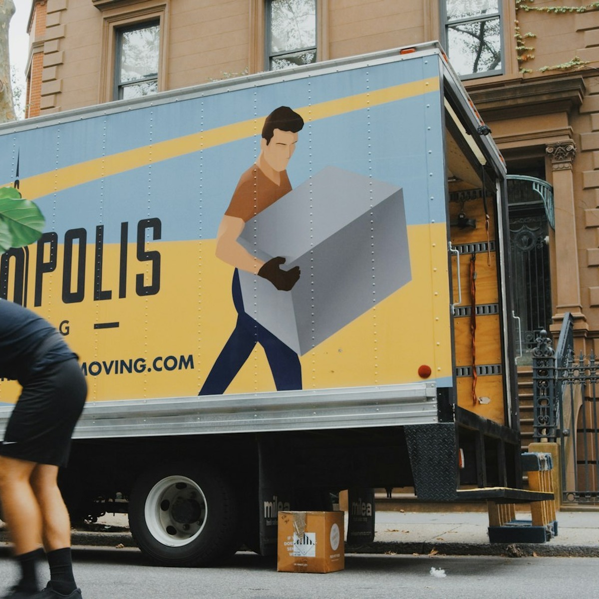 Professional mover carrying a large heavy item beside a moving truck, representing heavy furniture movers in Palm Beach Gardens, FL.