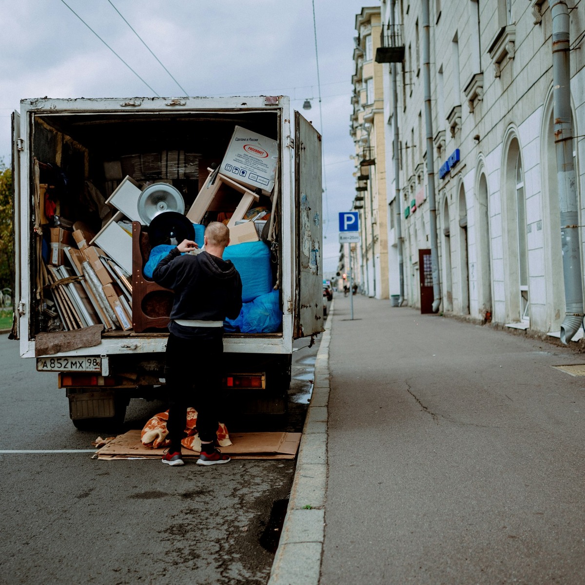 Professional mover loading bulky household furniture and belongings into a moving truck, representing heavy furniture movers near me.