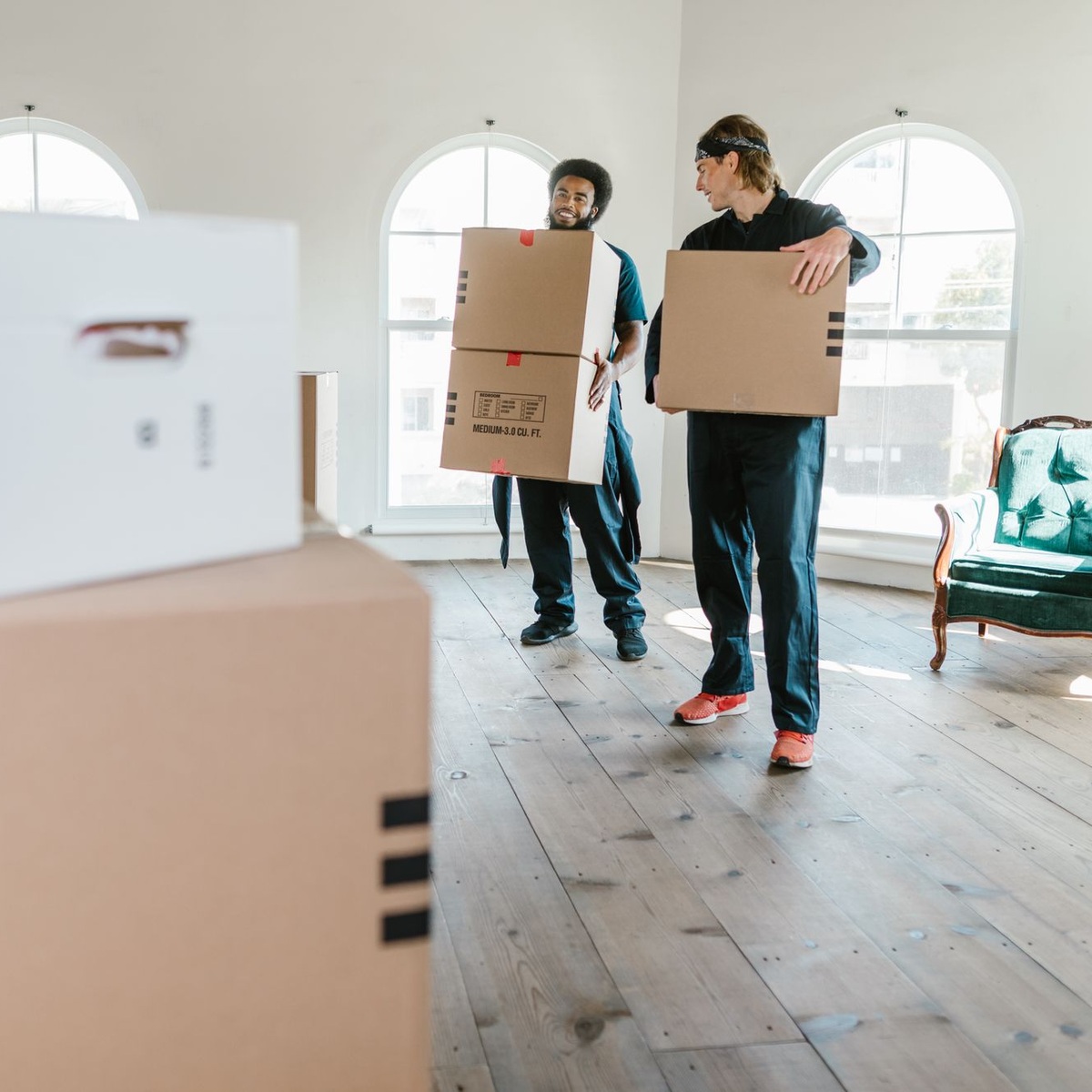Professional movers carrying moving boxes during moving services near me