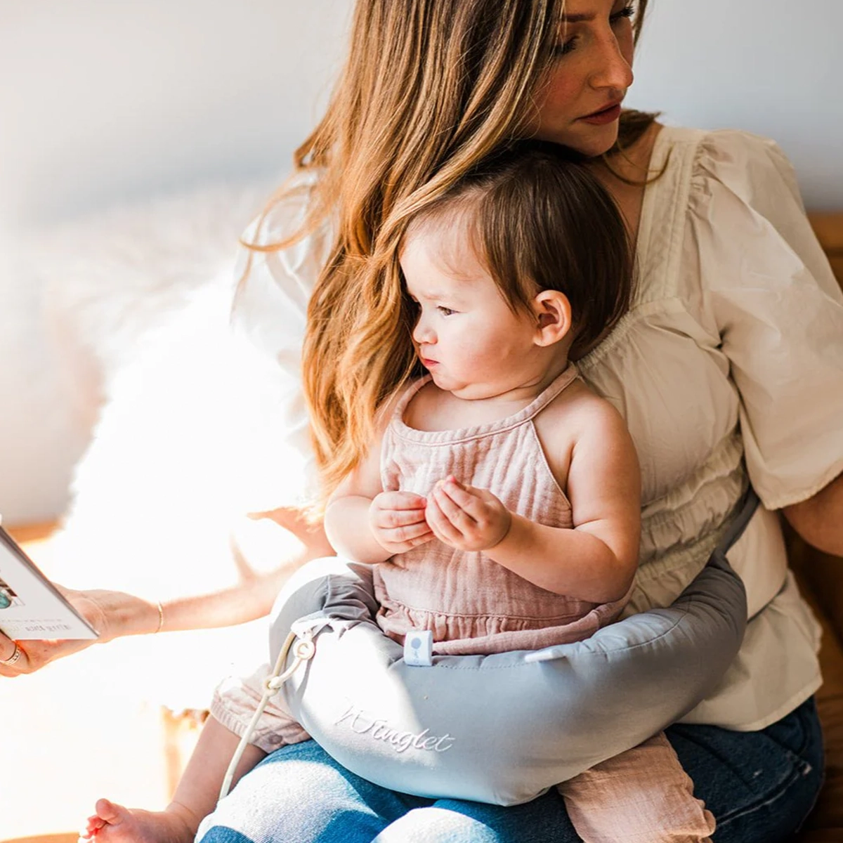 Winglet infant support pillow in use, keeping baby secure hands-free during travel