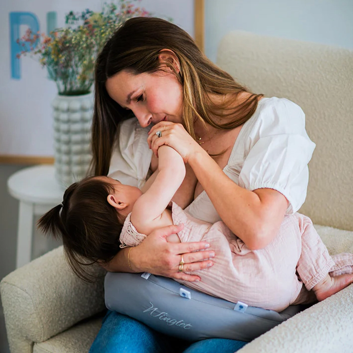 Winglet pillow used as a nursing support, showing adjustable positioning for breastfeeding
