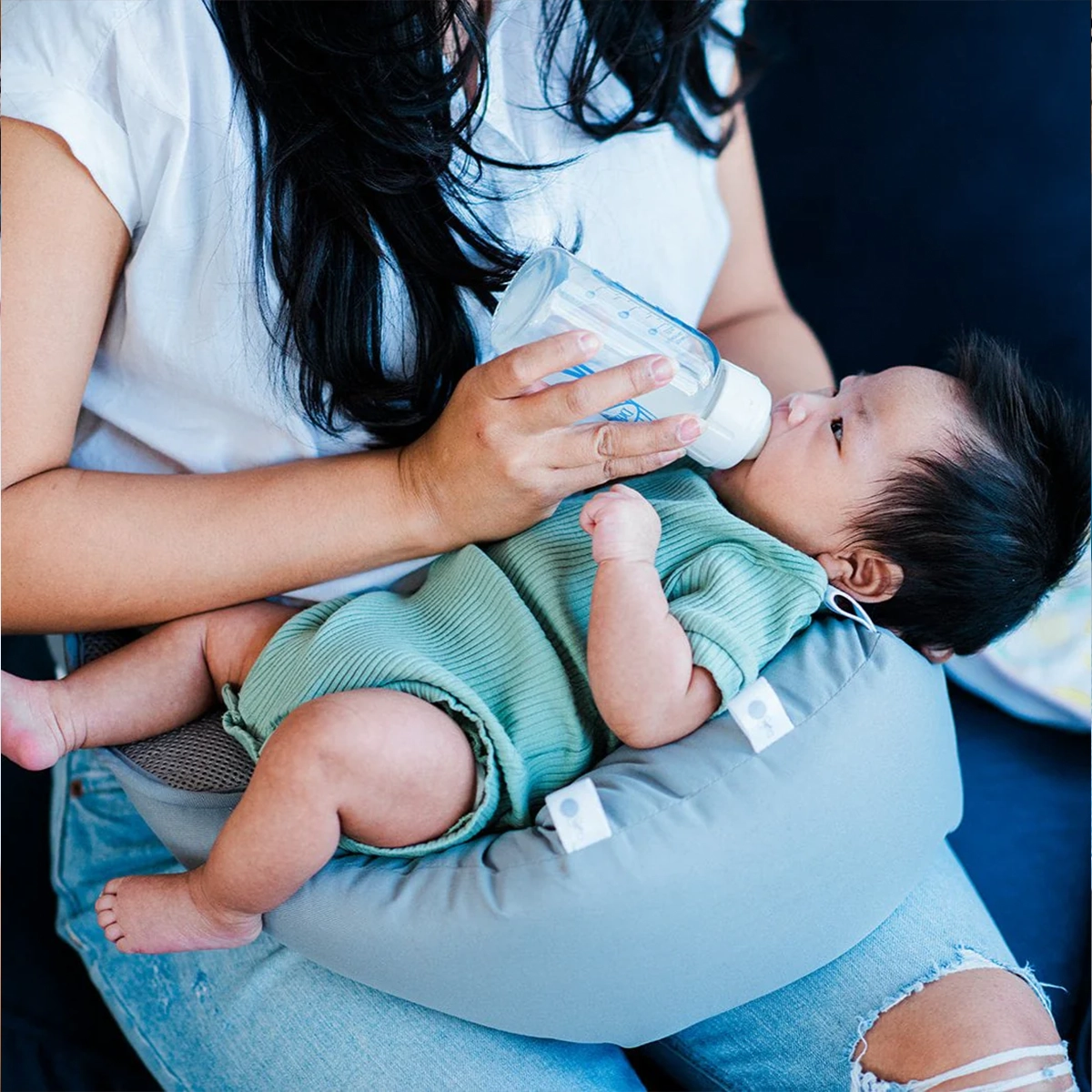 Parent using the Winglet to support an infant during feeding on an airplane