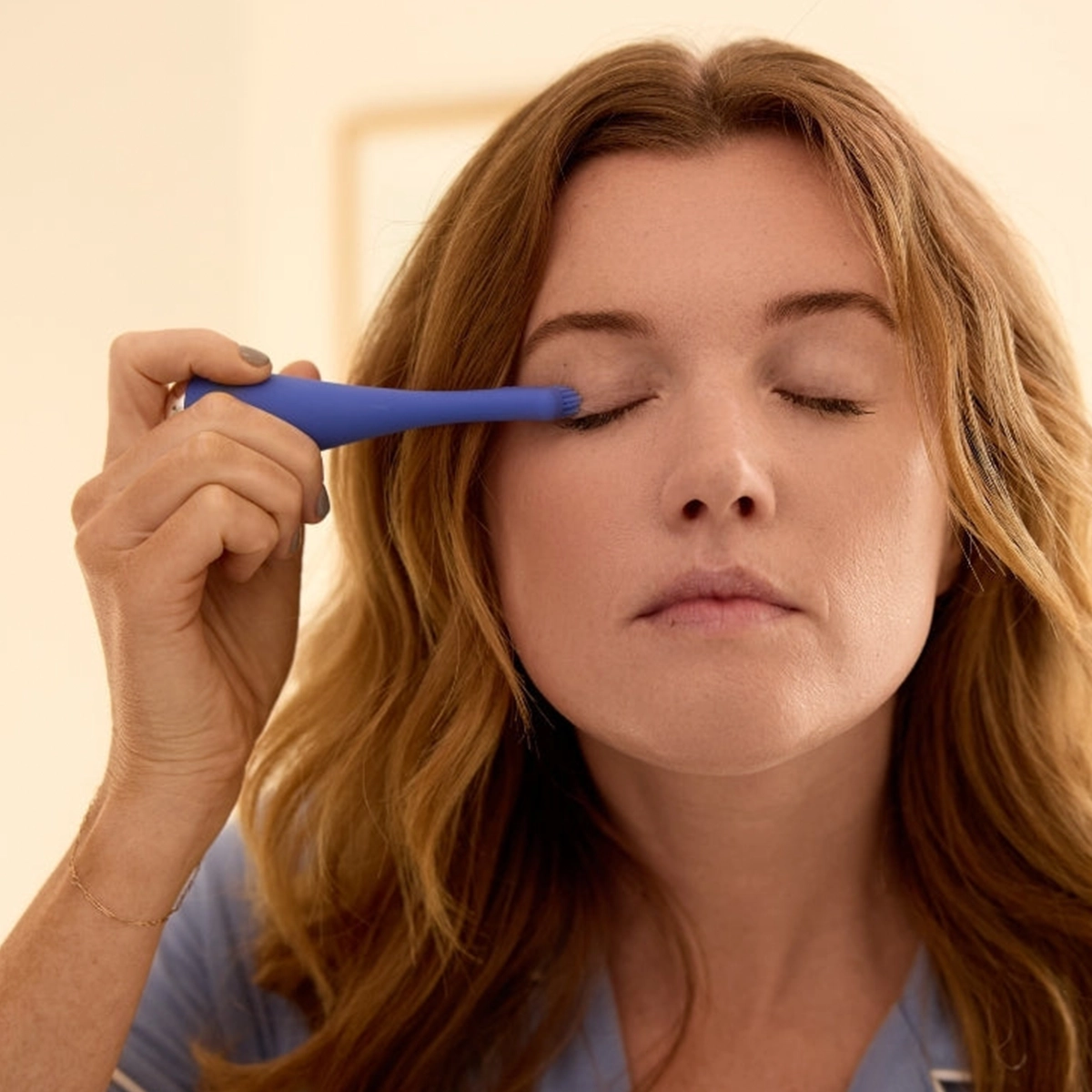 Blinkjoy electric eyelid brush being used to clean lash line, showing gentle tip contact