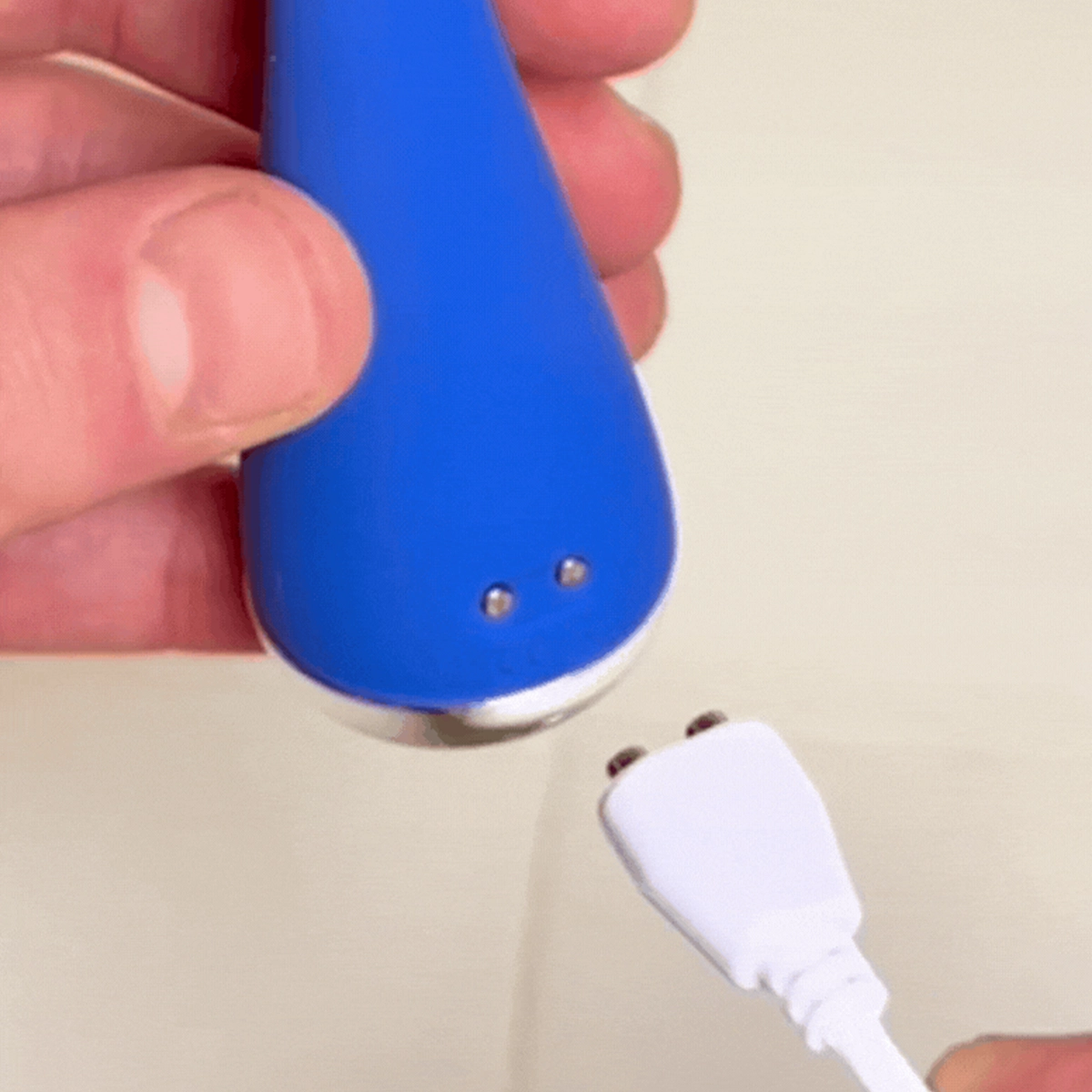 Blinkjoy electric eyelid brush on its USB charging base