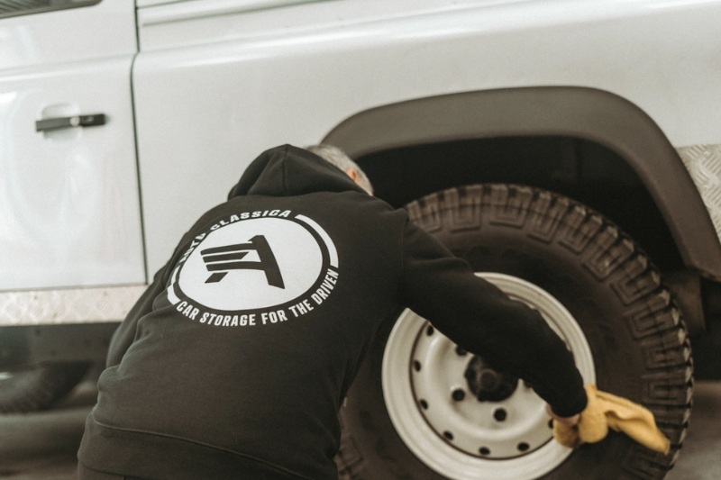 Routine car care in a dehumidified storage garage, including battery conditioning and tyre checks.
