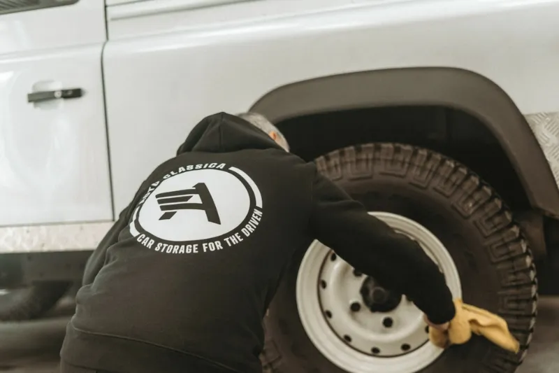 Routine car care in a dehumidified storage garage, including battery conditioning and tyre checks.