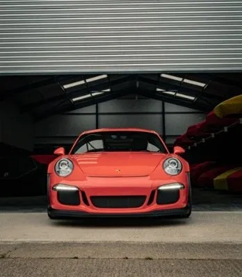 Supercar exiting the secure, monitored warehouse gate at Auto Classica in Milton Keynes.