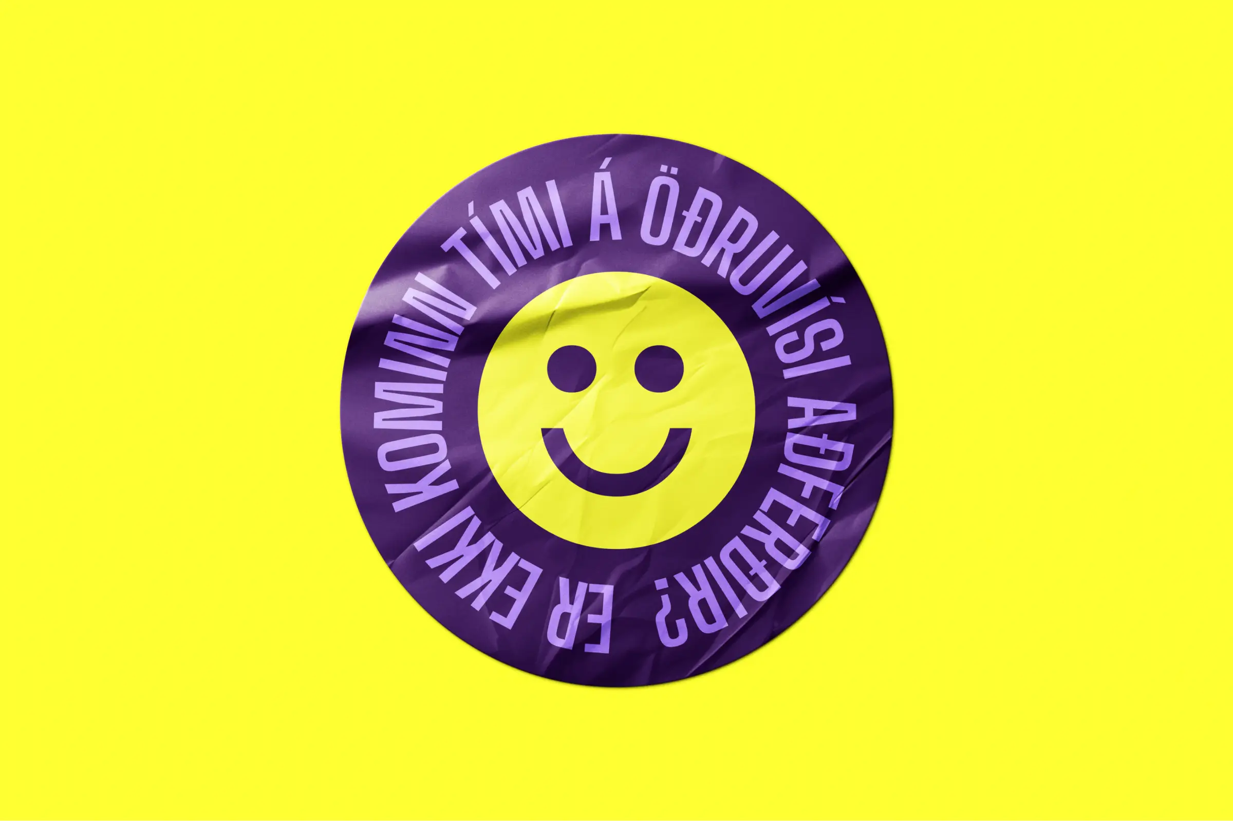 Purple sticker on yellow background, featuring a smiling face and Icelandic text.