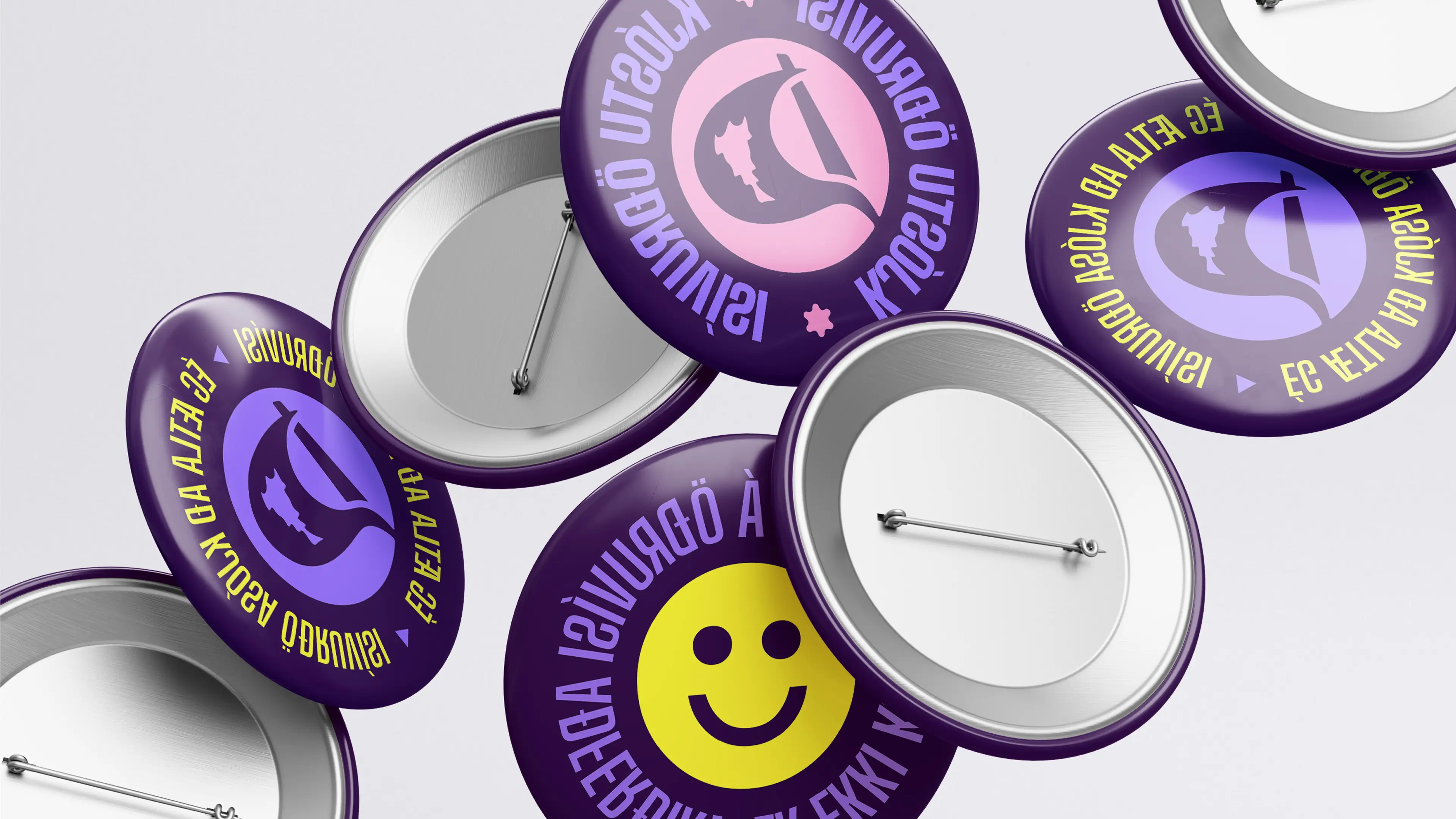Colorful enamel pins feature smiley faces and Icelandic phrases in vibrant purple, pink, and yellow hues.