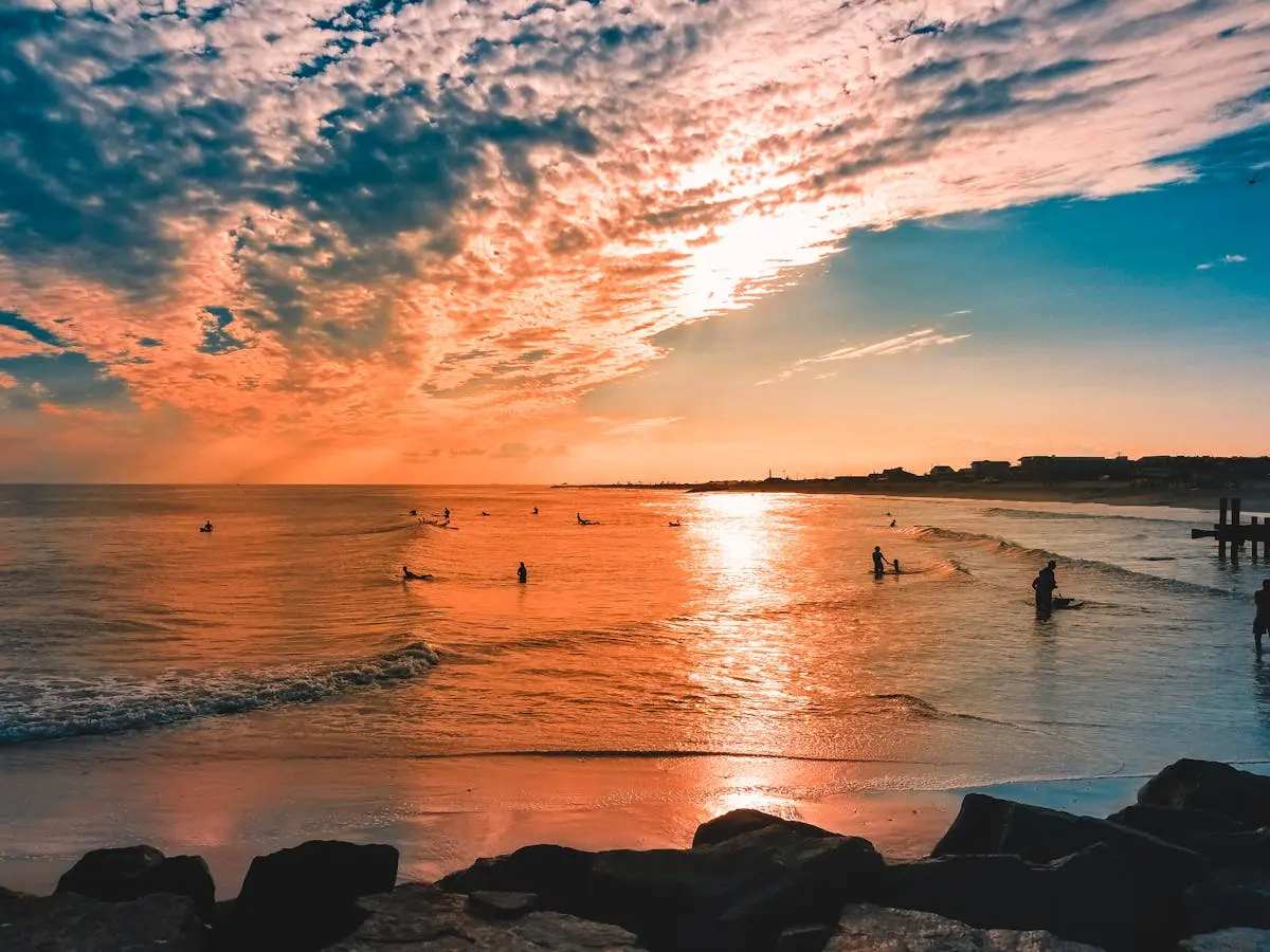 Surfers in the ocean at sunset along the Jersey Shore, representing 3D Printing by Bokey’s service area in South Jersey.