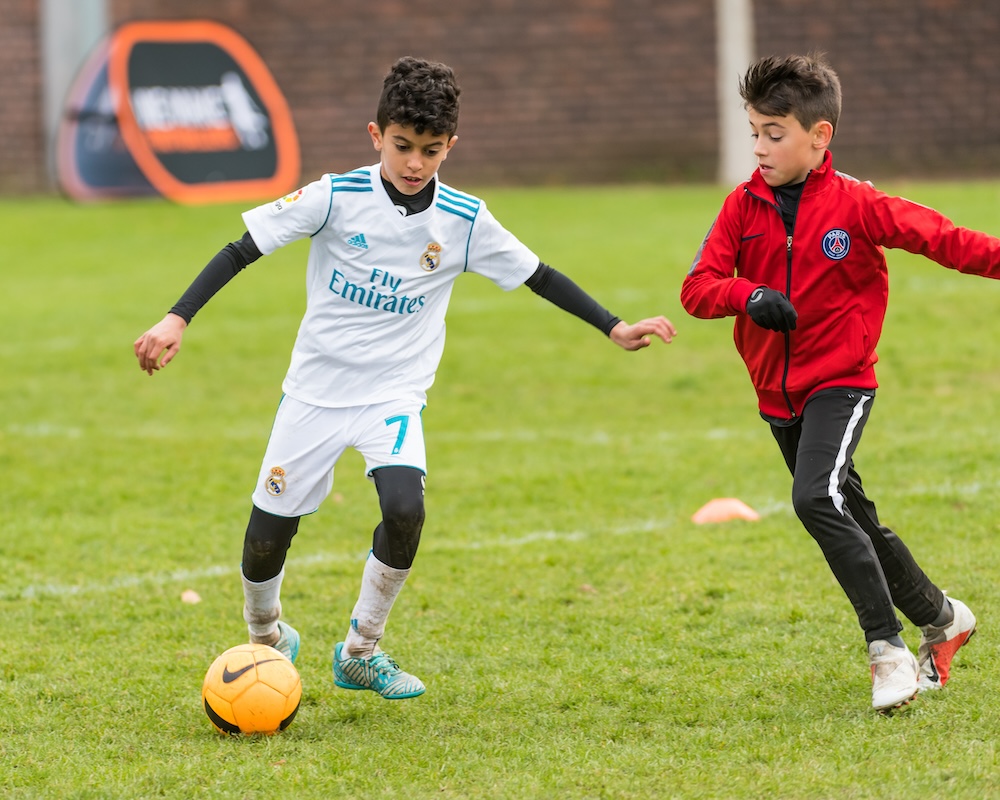two football players challenging for the ball during football training