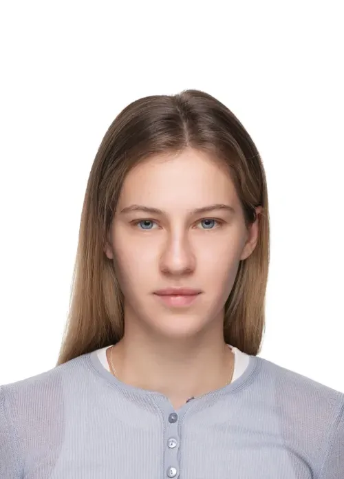 Front portrait of a young woman with straight light brown hair and blue eyes wearing a grey shirt.