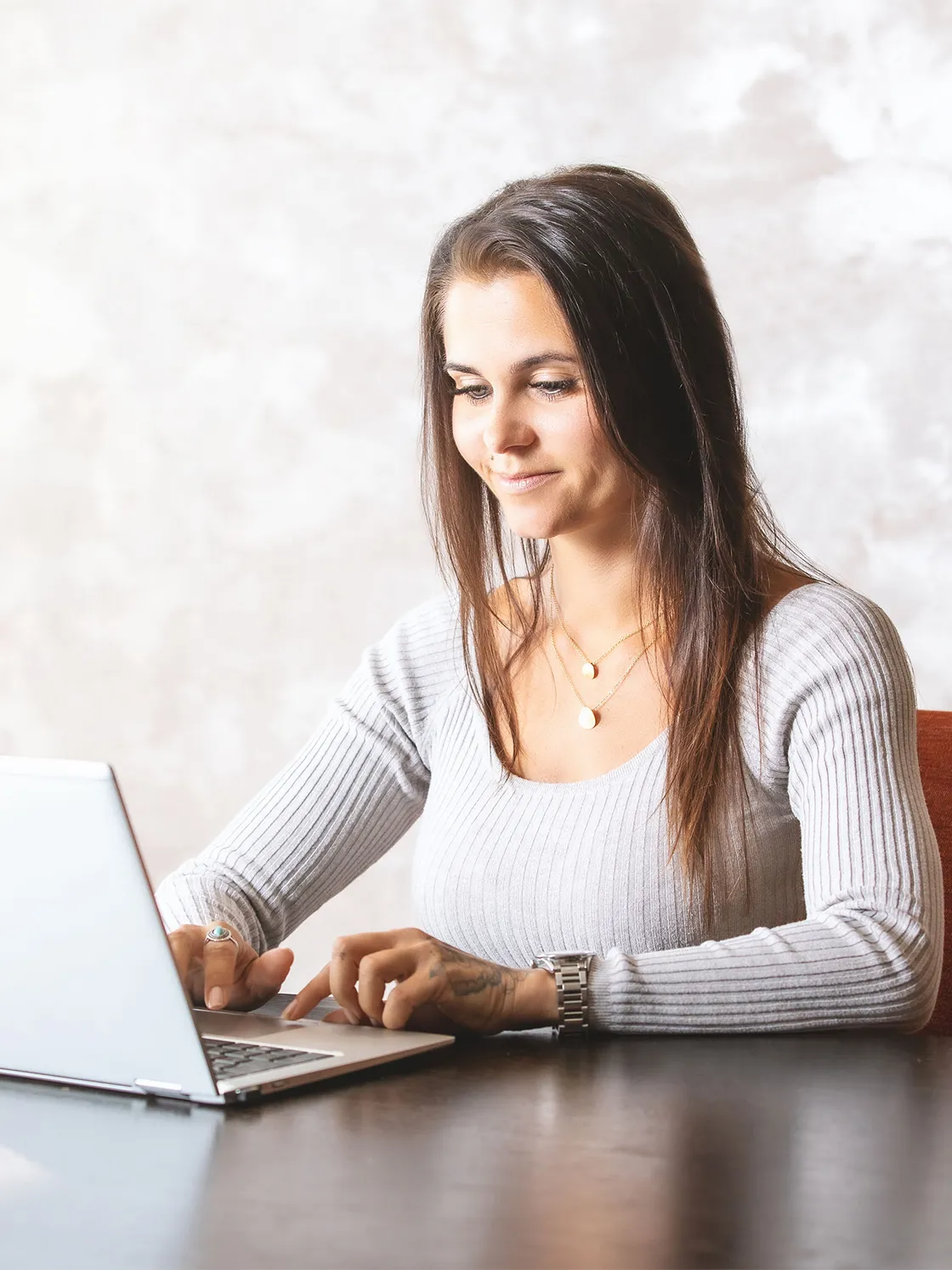 Natascha rechnet die Kosten für eine neue Website aus am Laptop