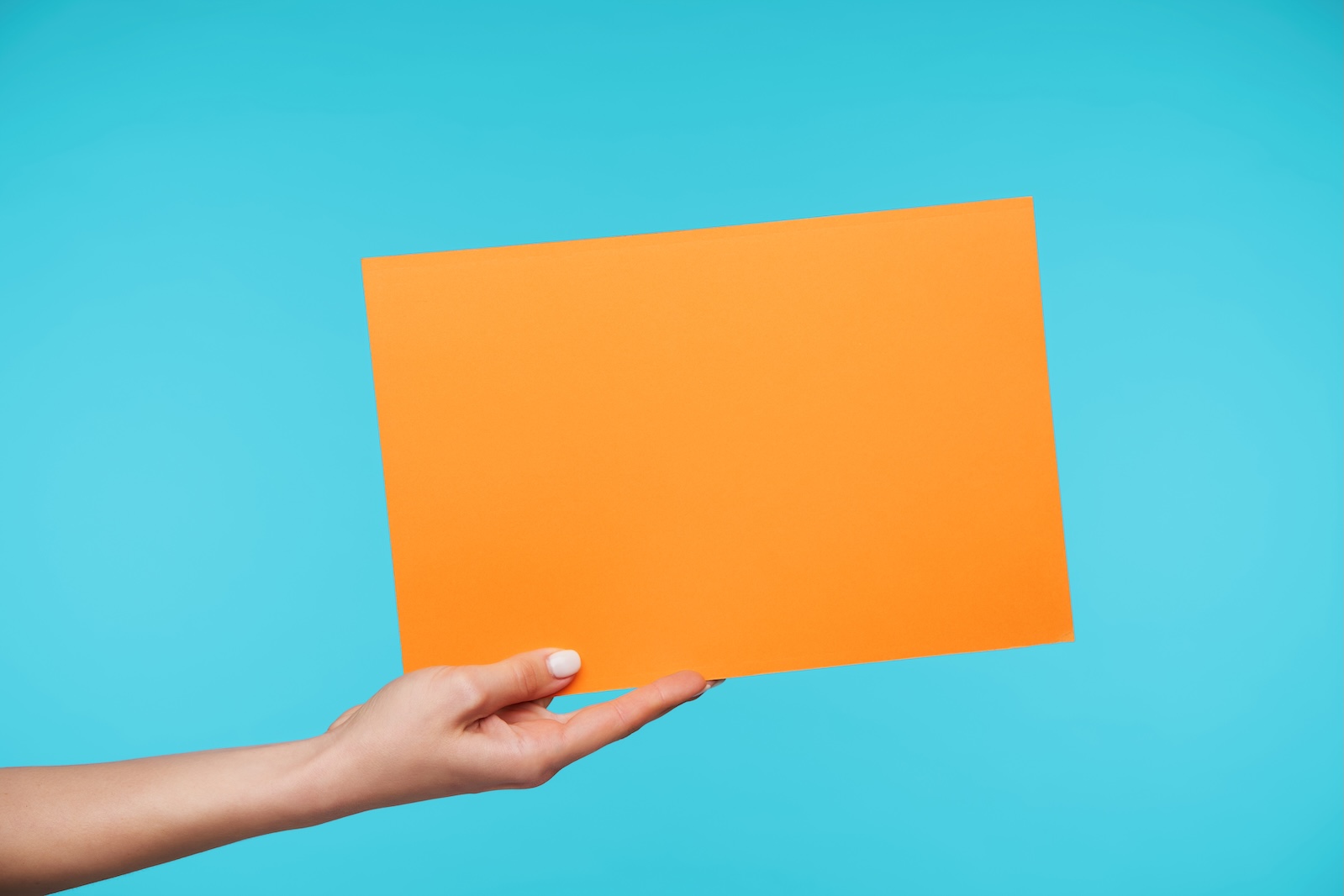 a person's hand holding a manilla envelope