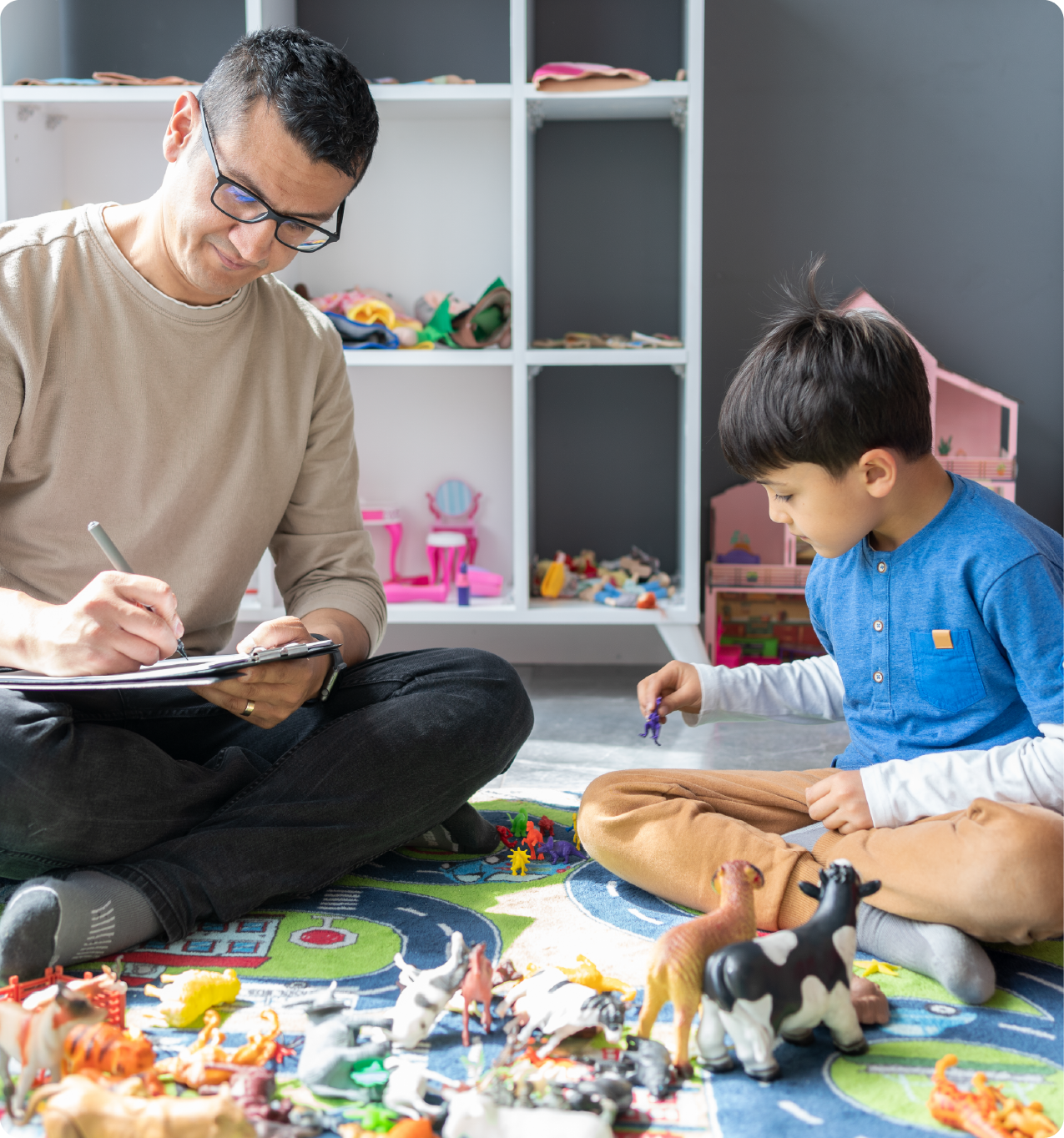 EPH Image: Man writing on chart as a young boy plays with toys