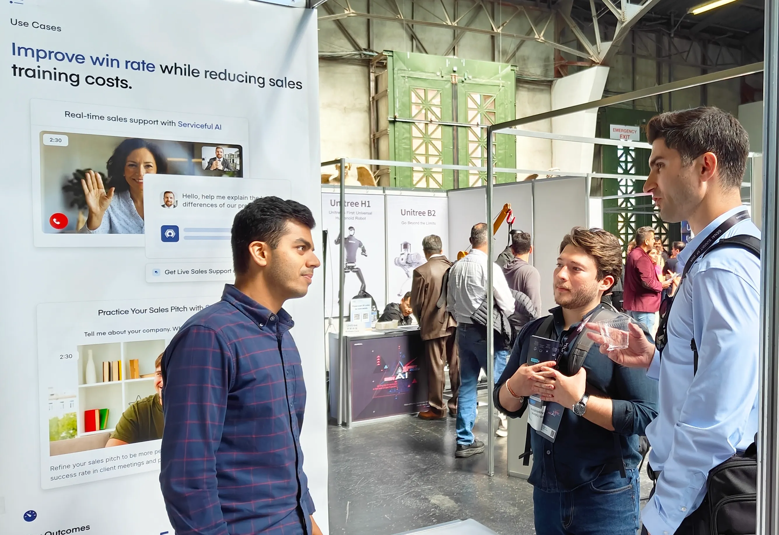Attendees talking at the Serviceful stand beneath a banner about reducing sales training costs