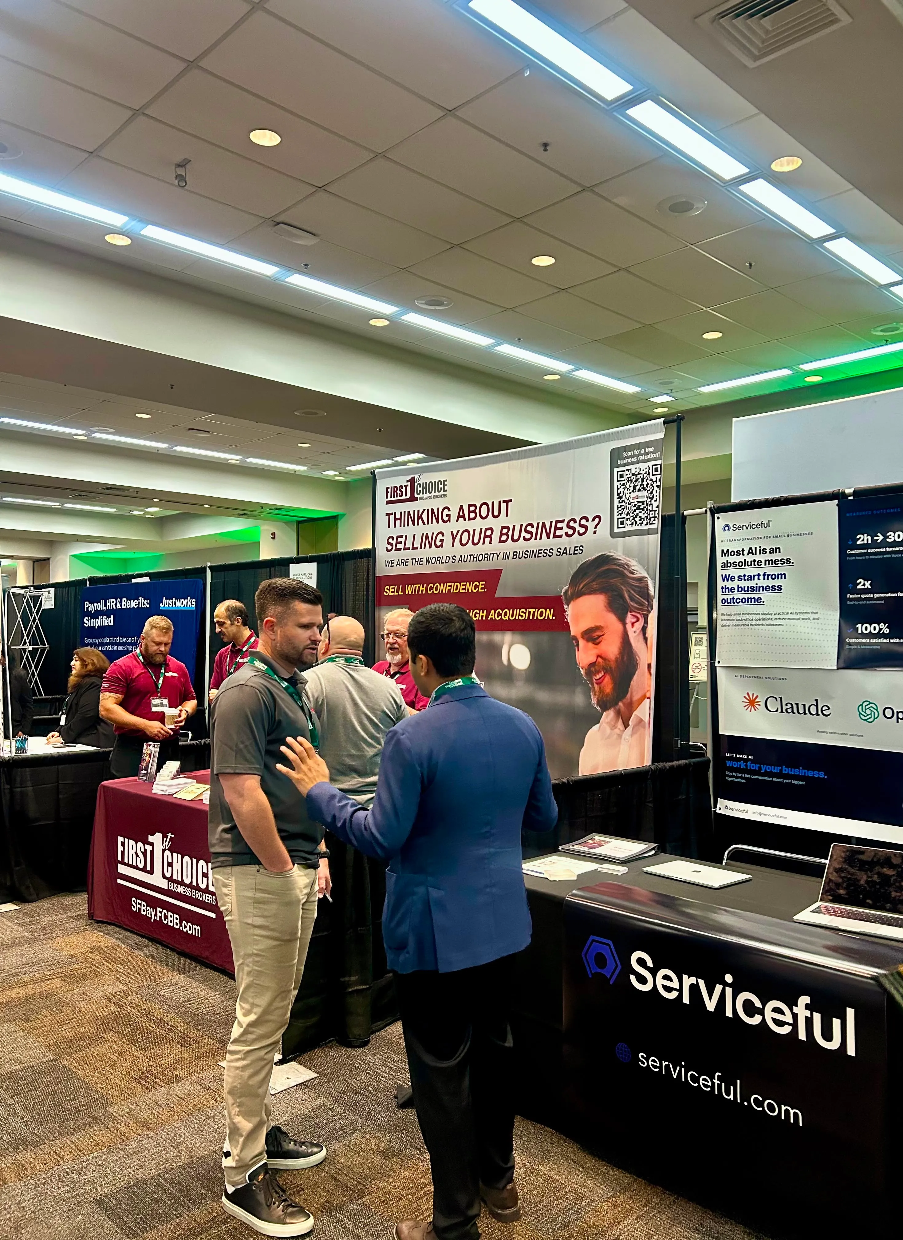 The Serviceful trade show booth displaying Claude and OpenAI partner logos alongside neighboring exhibitors