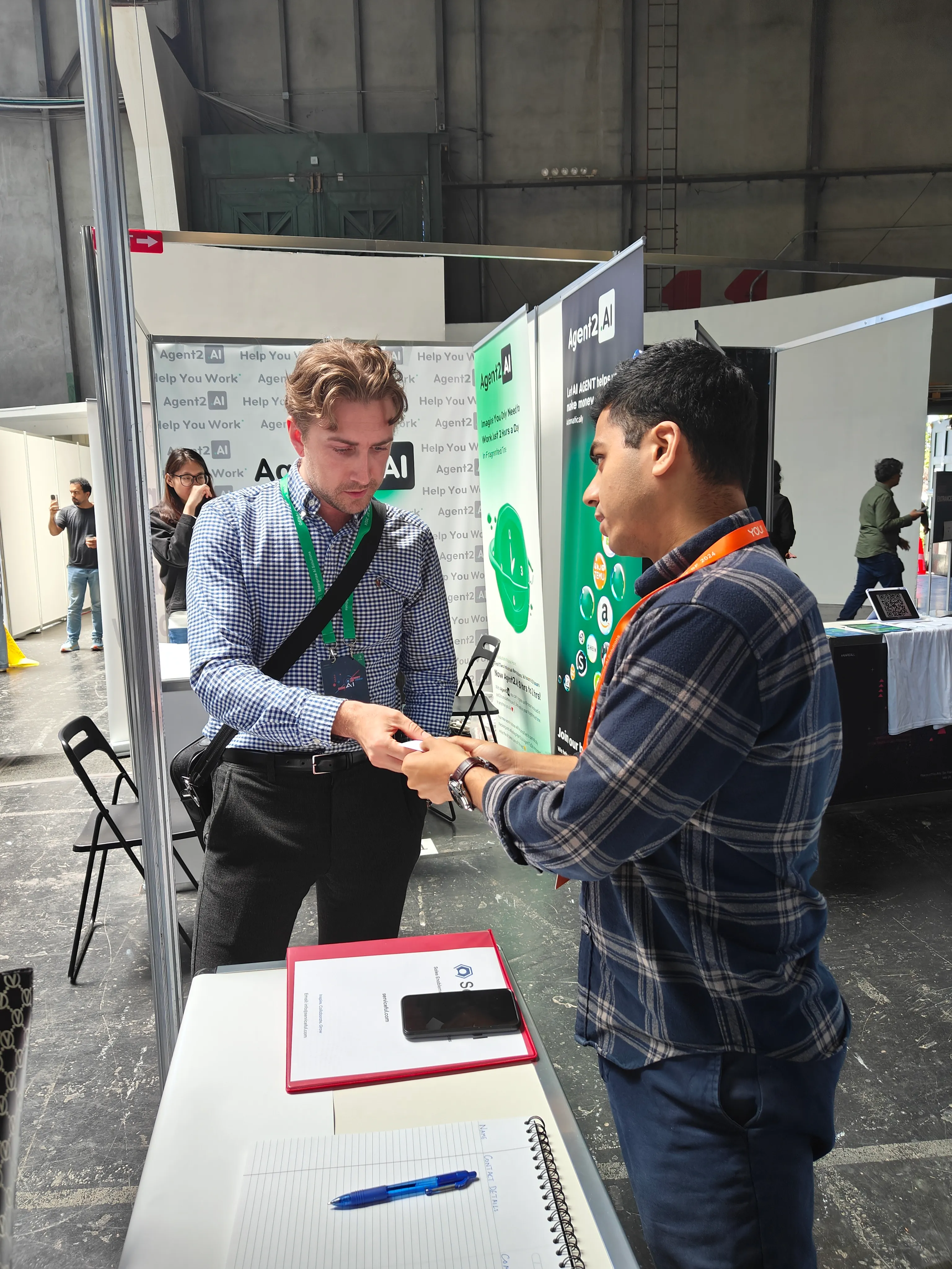 A Serviceful team member exchanging contact details with an attendee on the expo floor