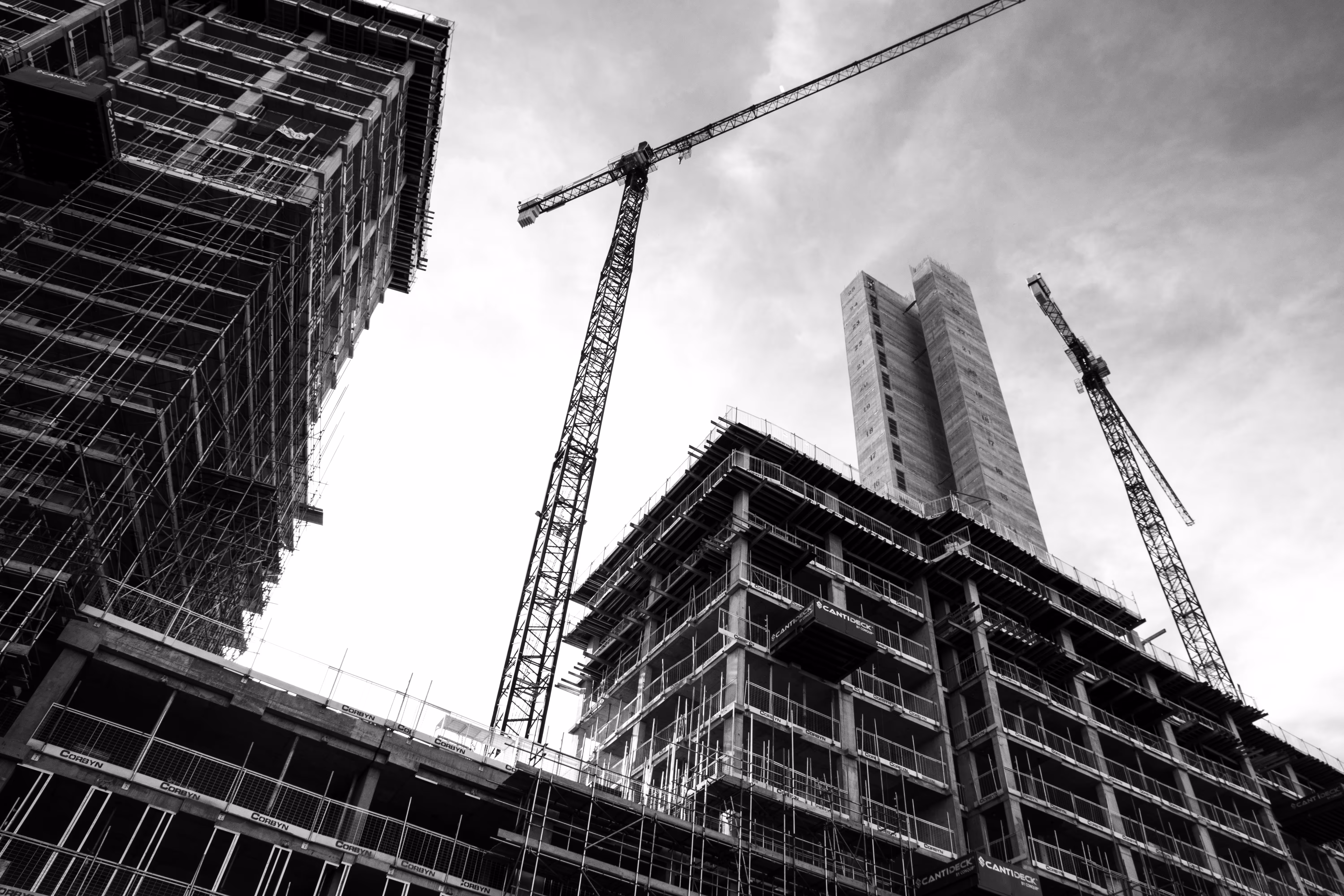Hochhaus-Rohbauten mit Baukränen und Gerüsten bei Großbaustelle.