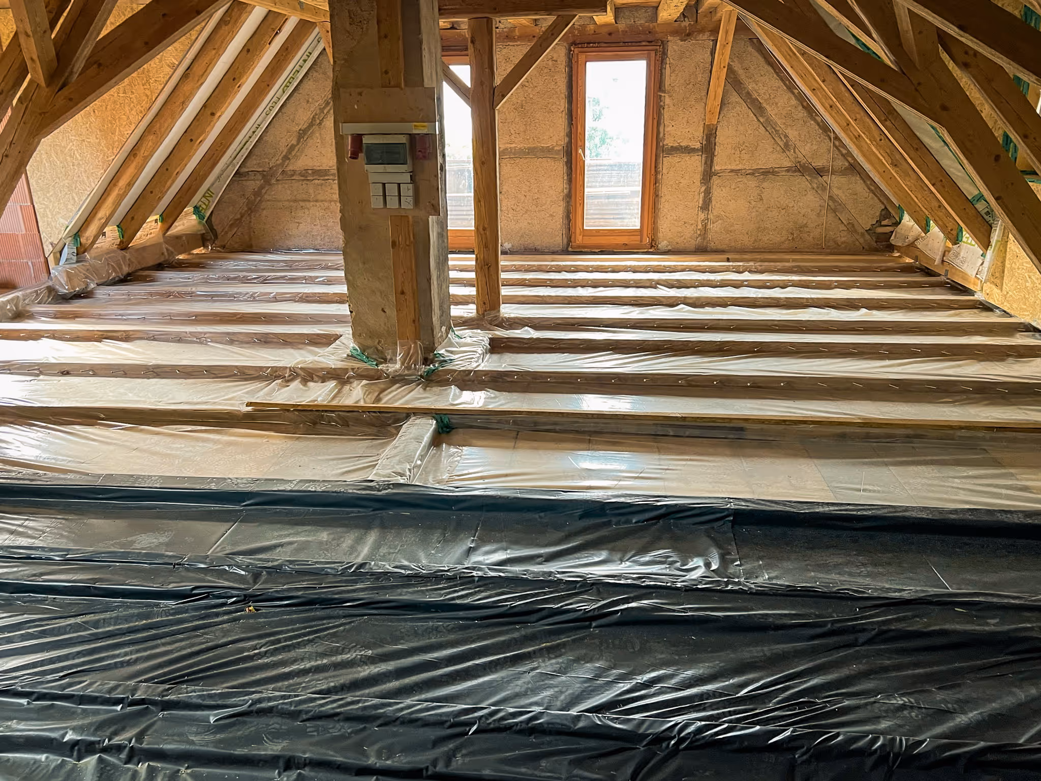 Dachboden mit neuer Balkenlage und Folienabdeckung.