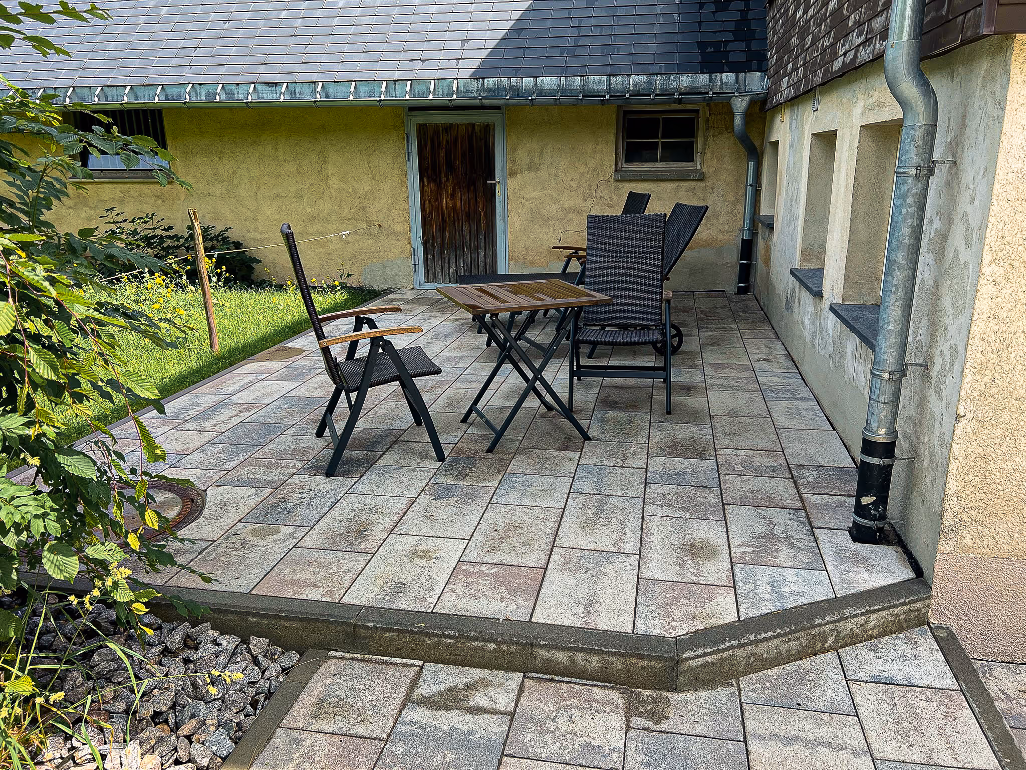 Neu gepflasterte Terrasse mit Gartenmöbeln – Außenanlagenbau für mehr Wohnqualität.