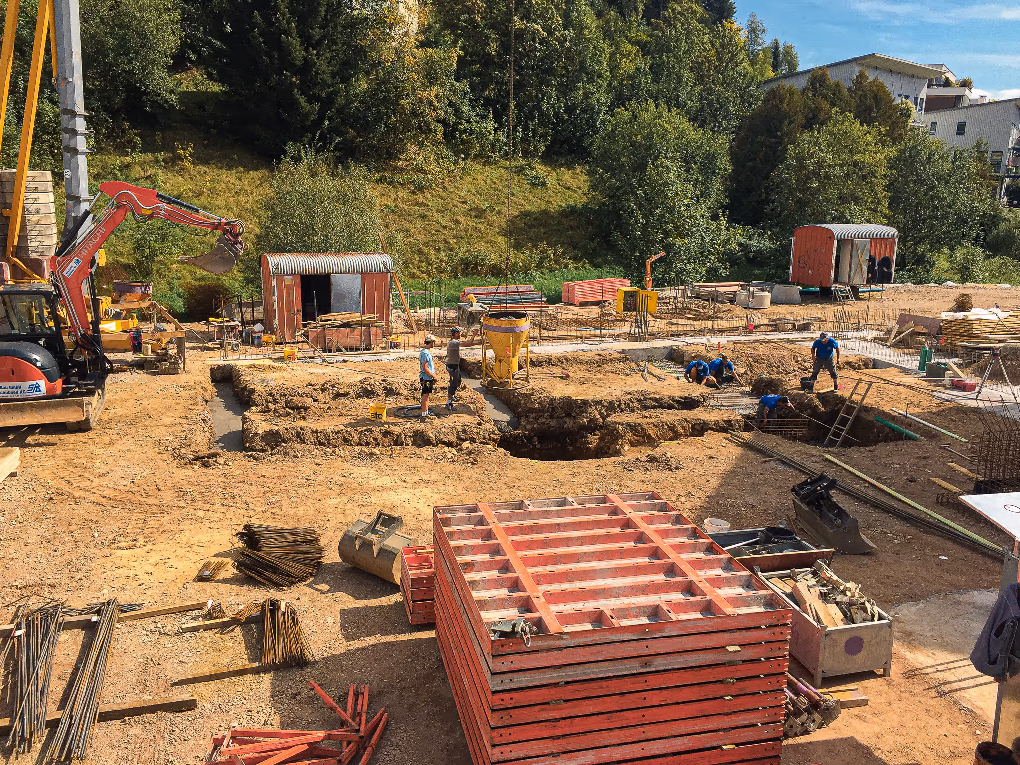 Arbeiter führen Aushub- und Fundamentarbeiten auf einer Baustelle durch.