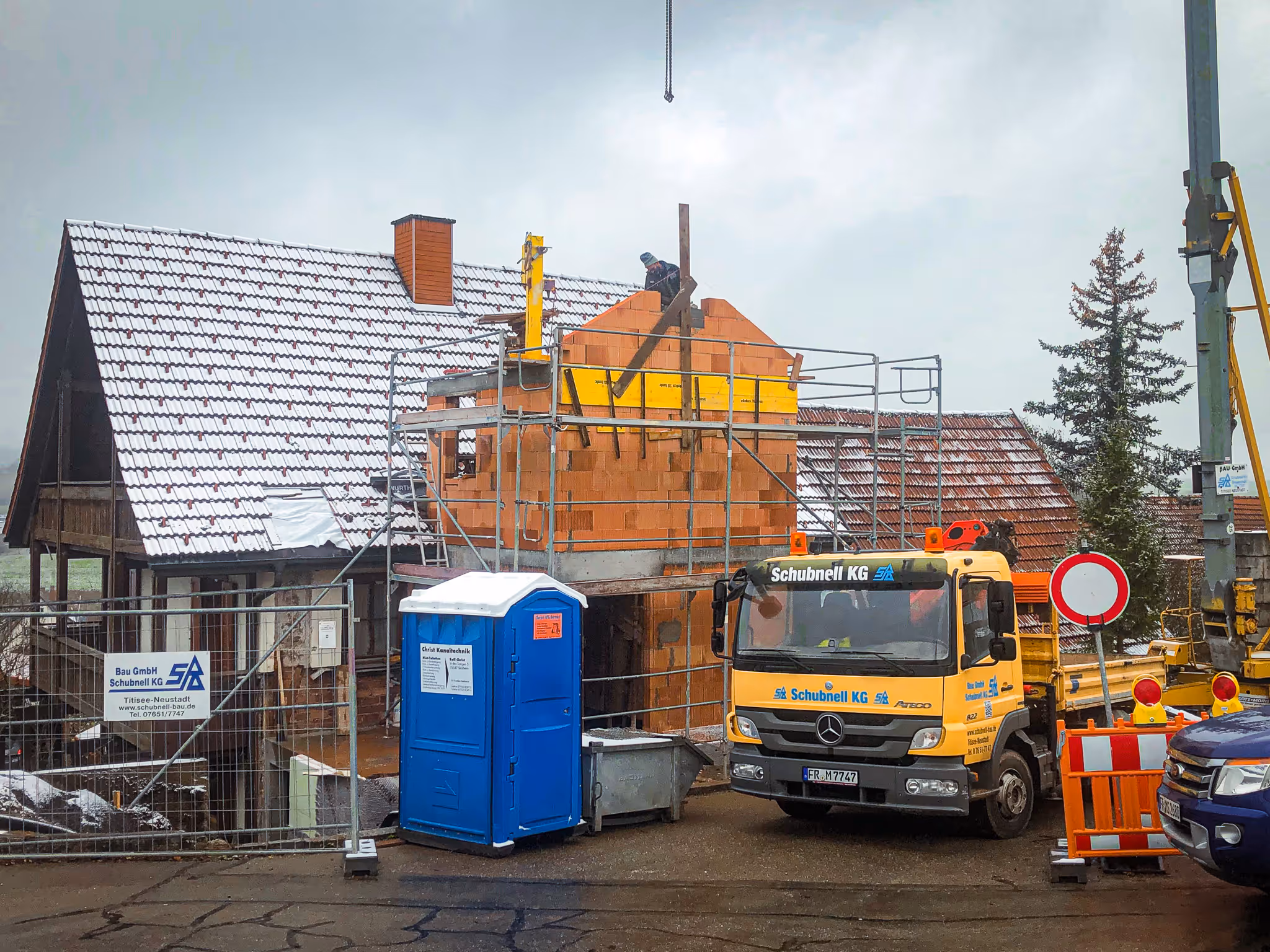 Rohbau mit massiven Betonwänden, Bauarbeiter bei der Vorbereitung von Mauerarbeiten mit Ziegeln.
