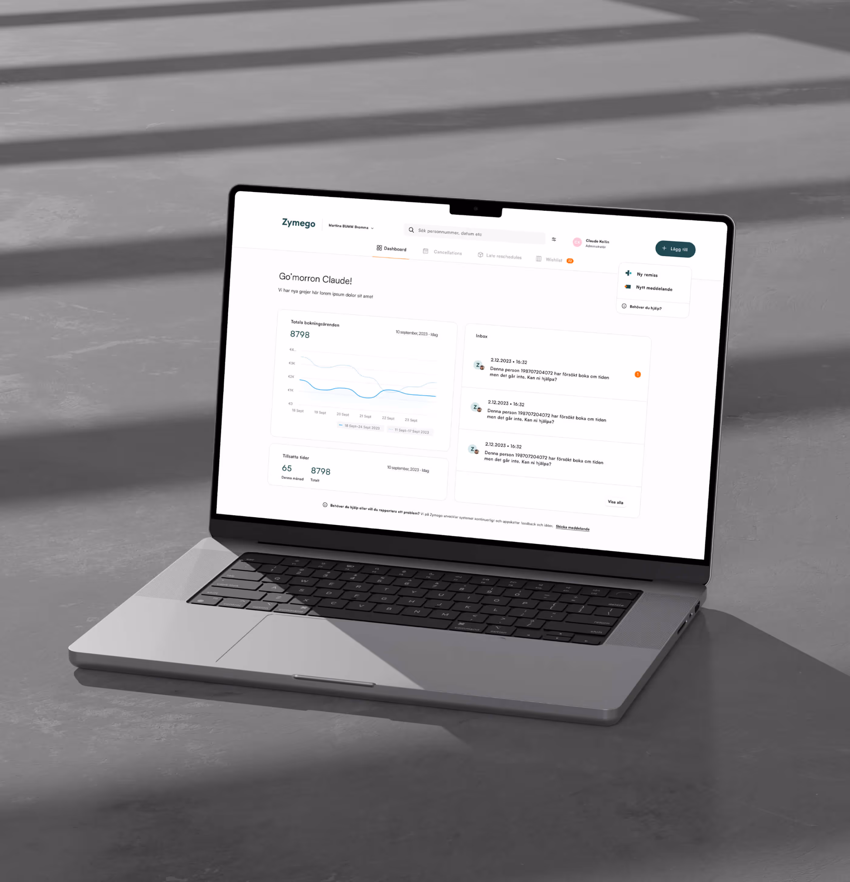 Bärbar dator på golv som visar Zymego-instrumentpanel med bokningsstatistik och meddelanden på svenska.