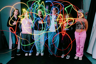 People drawing colored lines in the air.