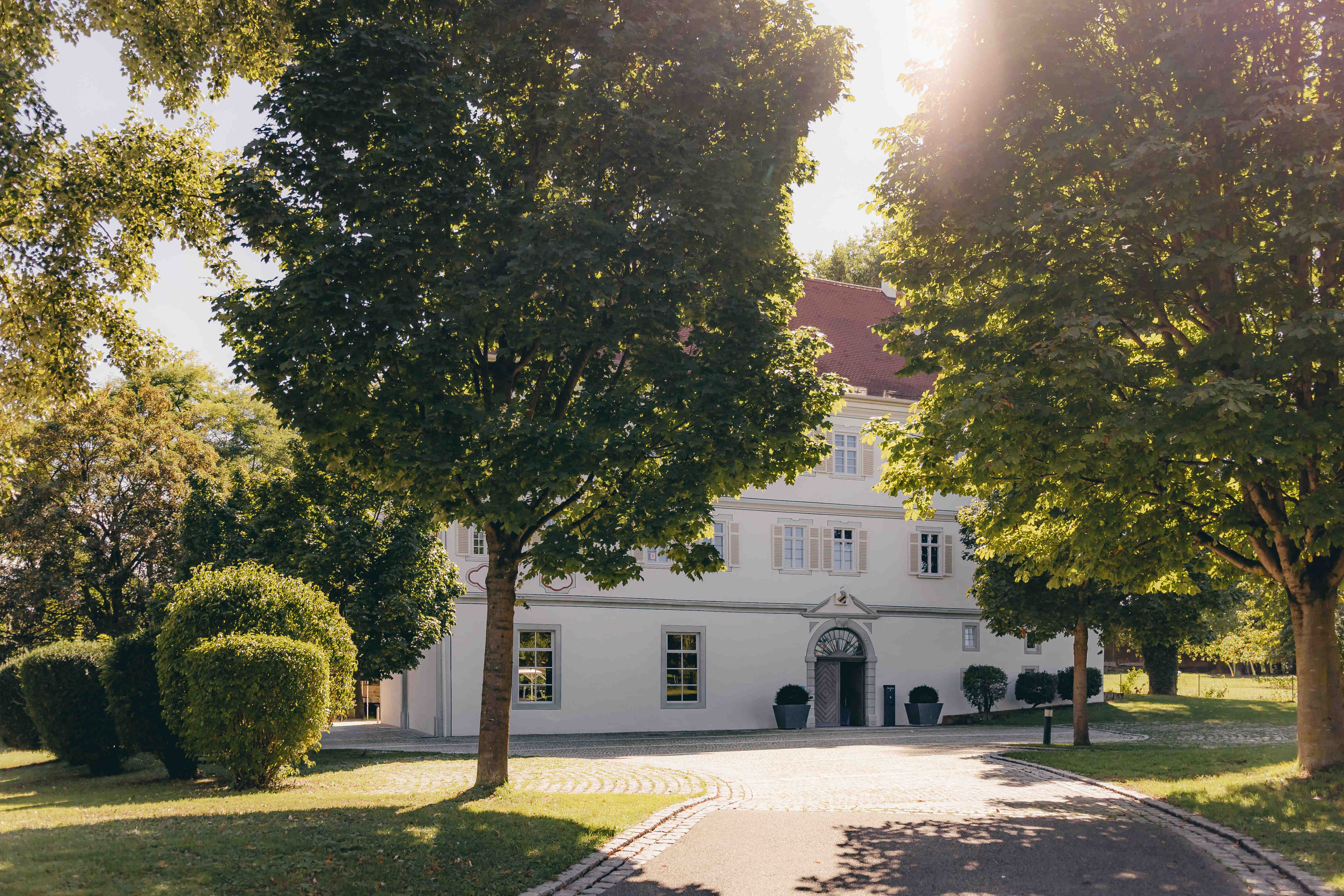 Lea und Cem stehen gemeinsam unter Leas Schleier im Schlosshof.