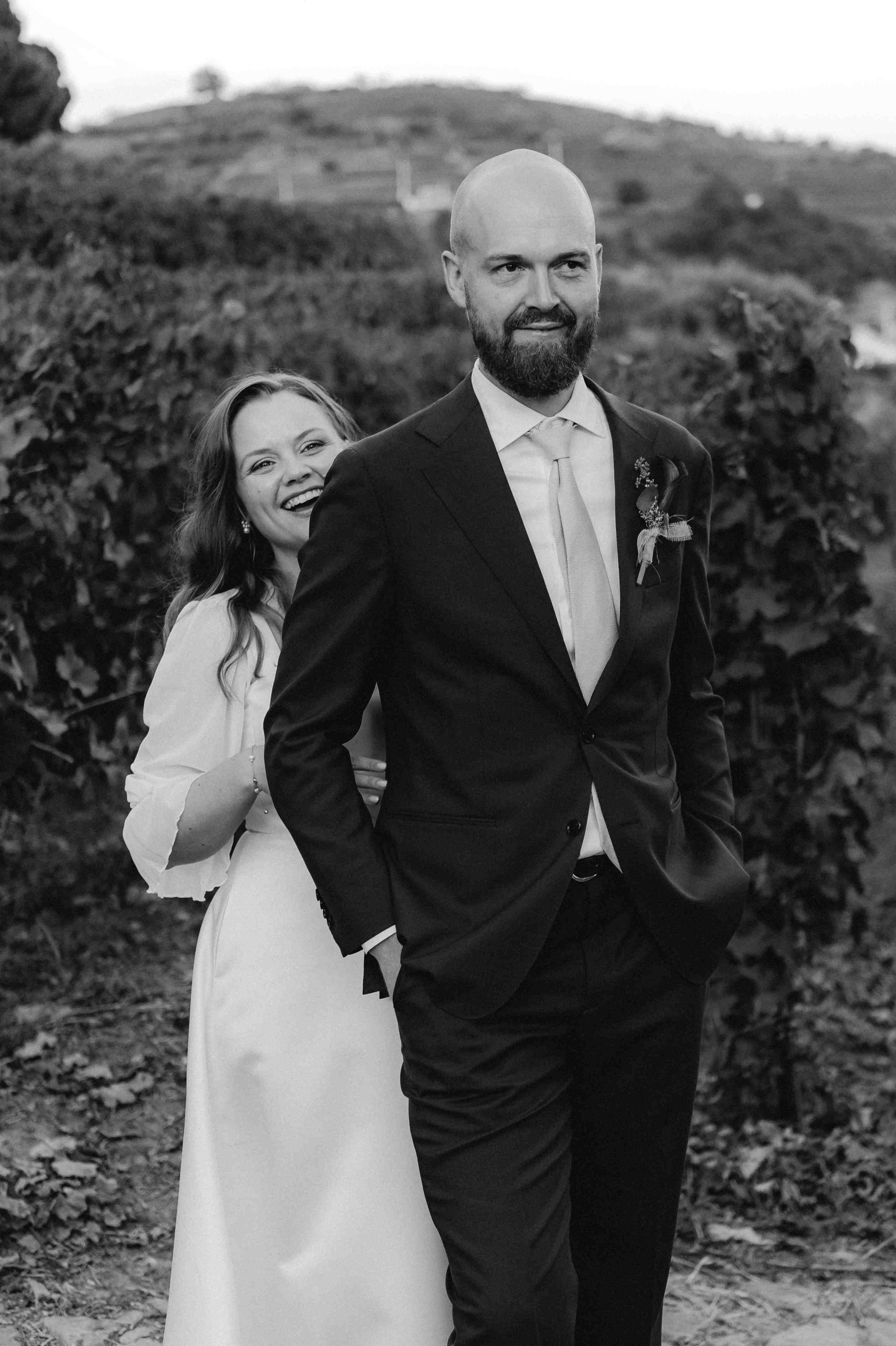 Melissa lehnt sich an Anders zwischen den Reben, fotografiert in Schwarzweiß.