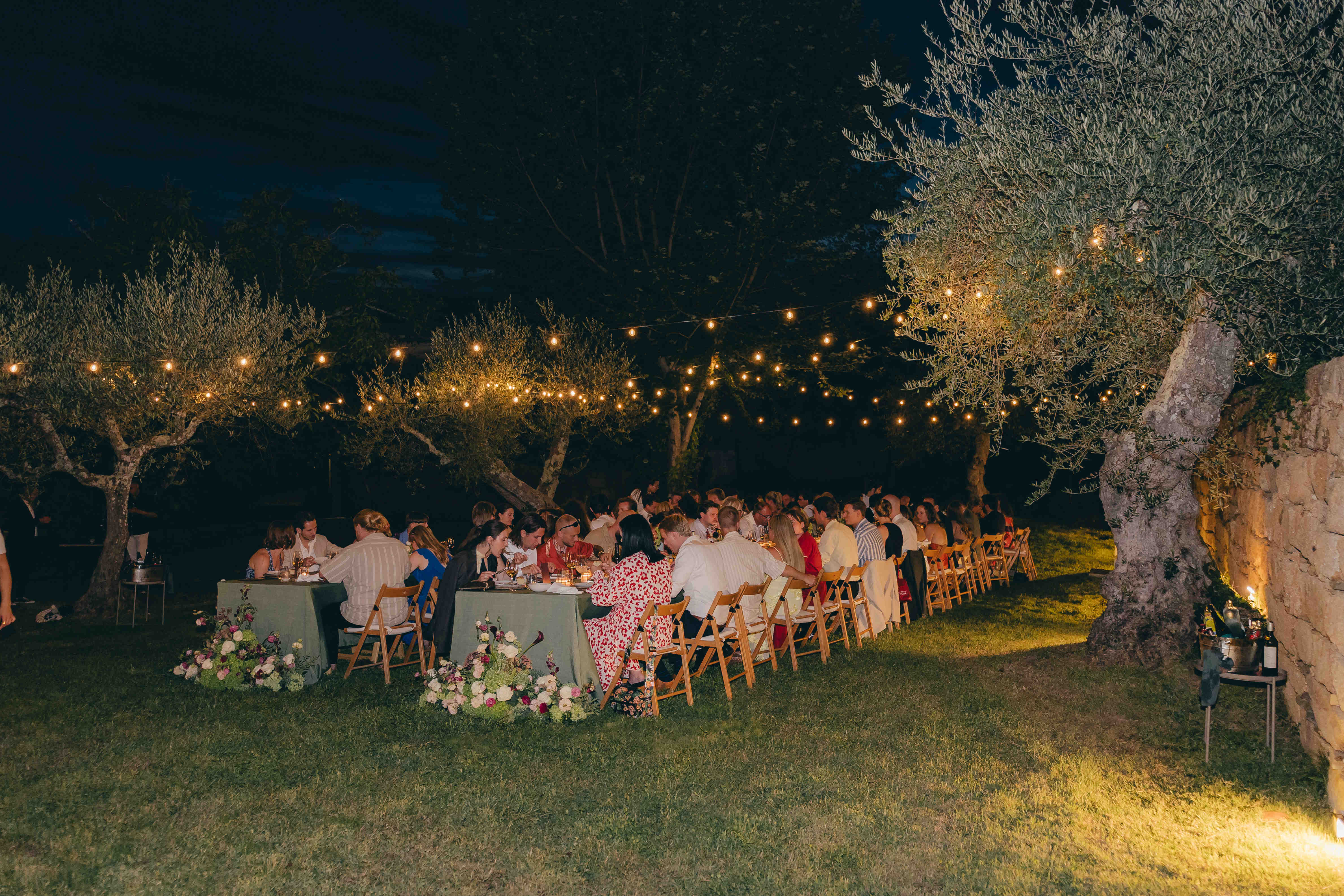 Die beleuchtete Hochzeitstafel unter dem dunklen Nachthimmel im Garten von Casal de Tralhariz.