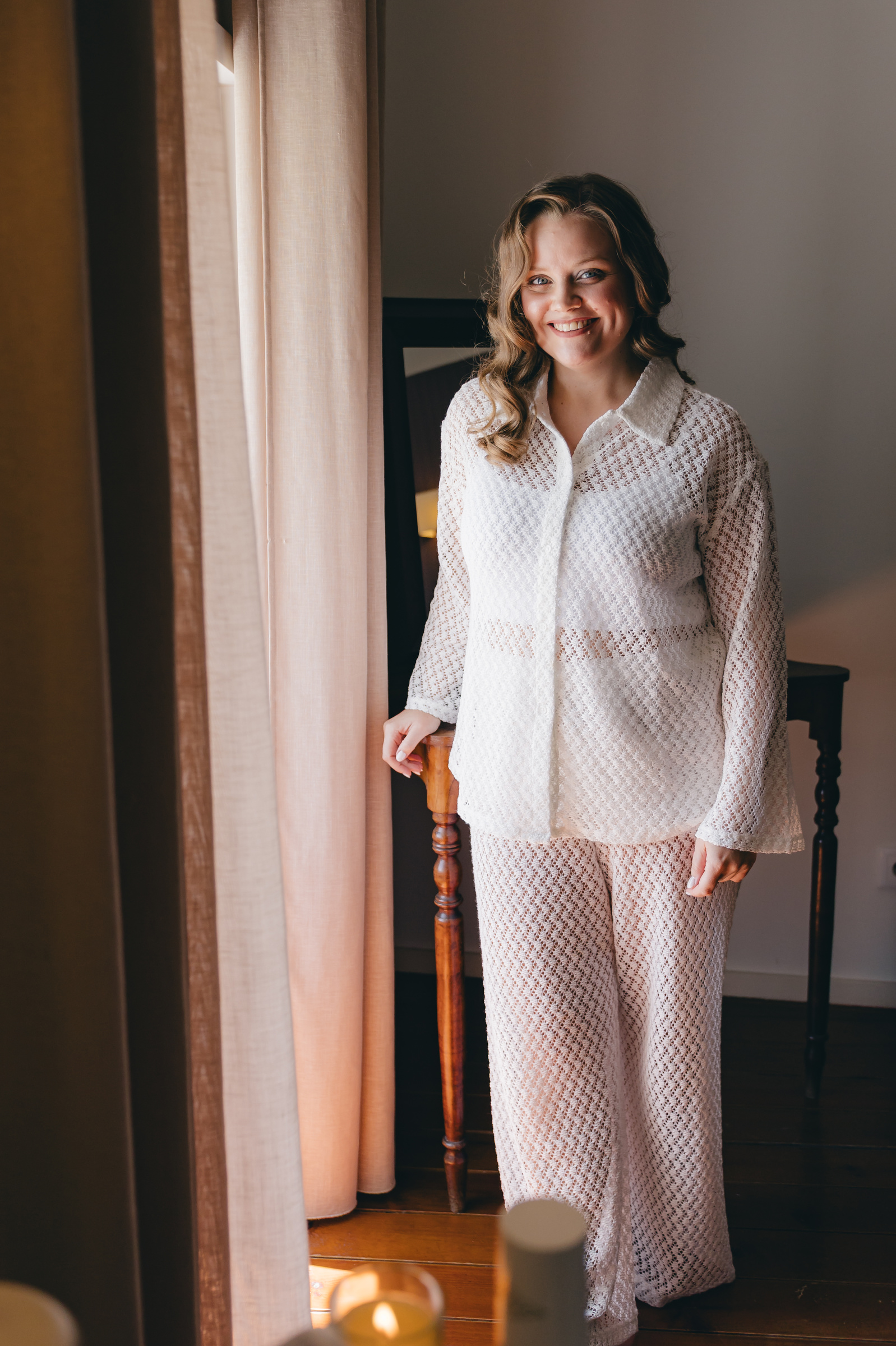 Melissa steht noch im leichten Morgenoutfit im warmen Fensterlicht.