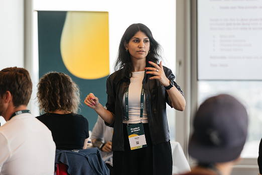 Zamina Ahmad hält einen Vortrag vor einem Publikum in einem modernen Konferenzraum.