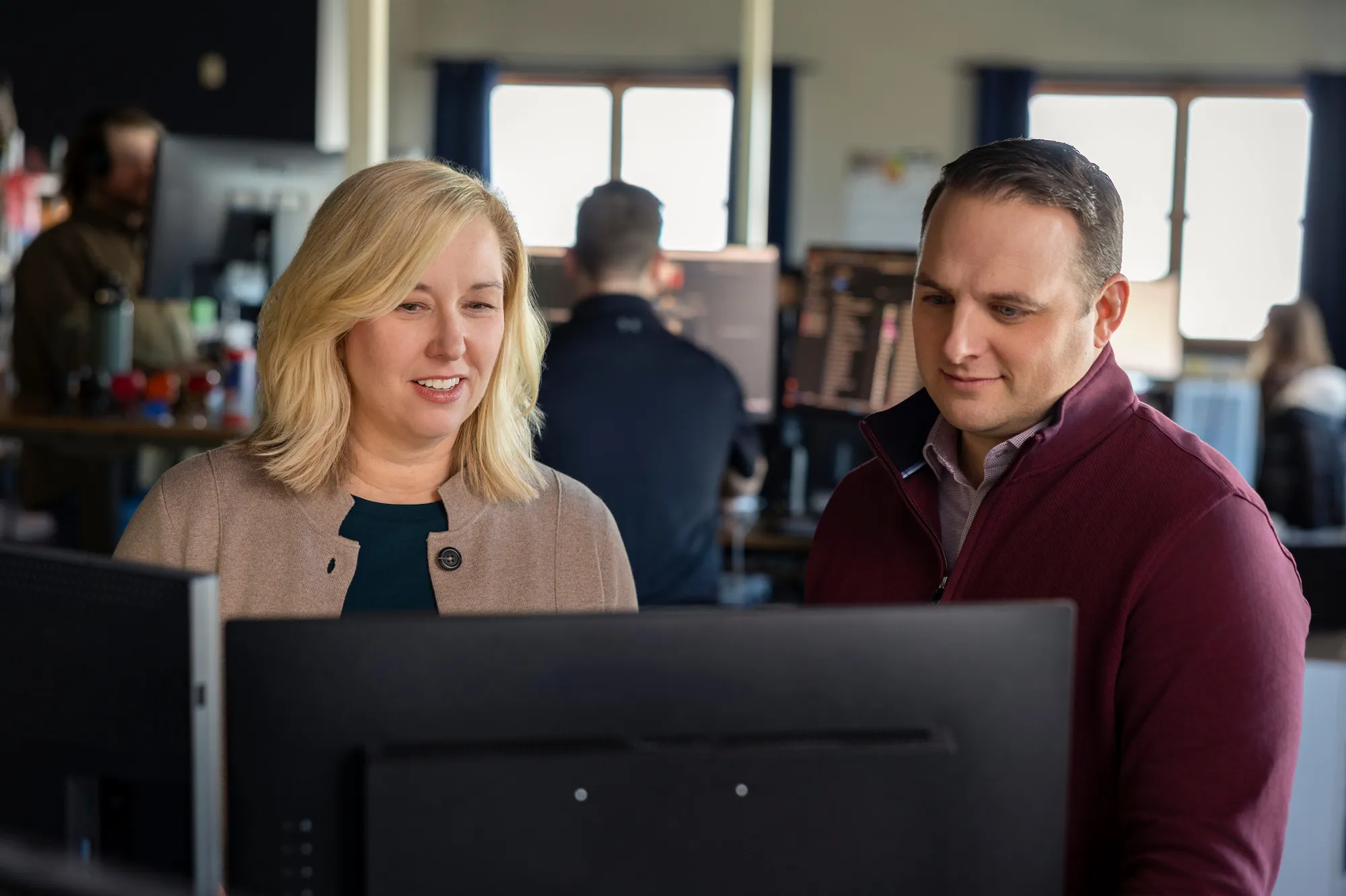 a man and woman working on a computer together