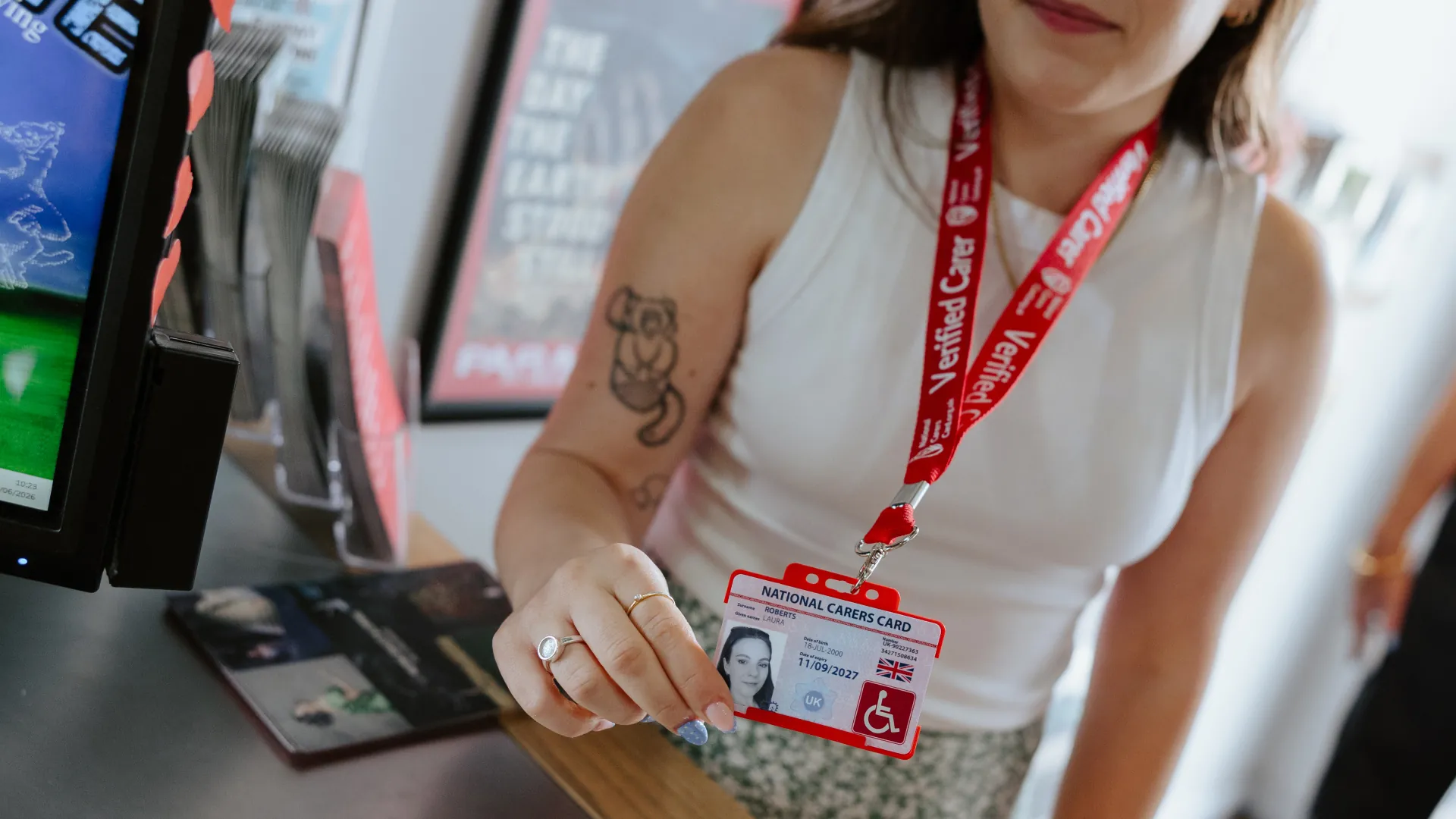 national disability card holder showing her card at a venue for carer ticket access