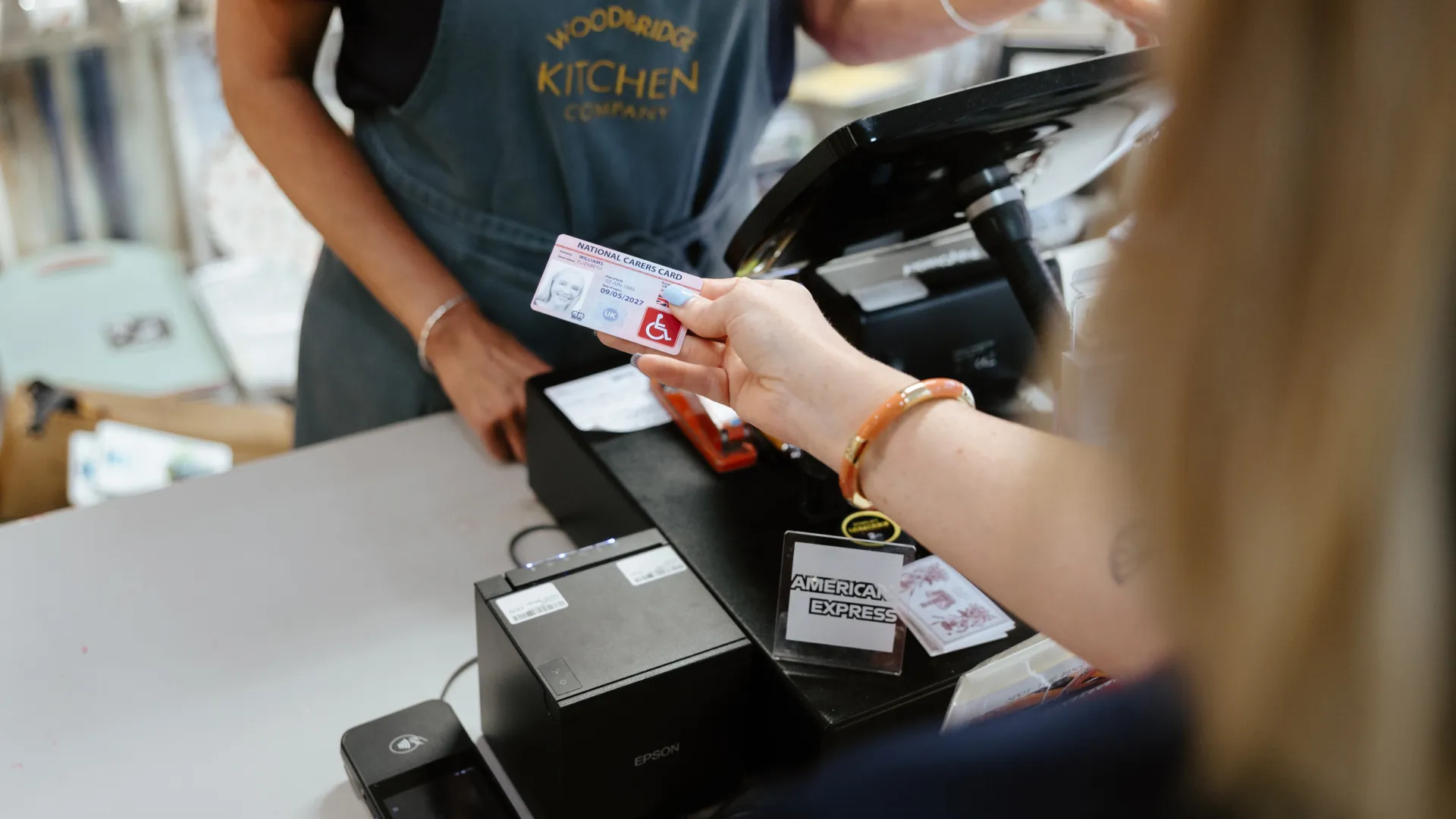 national disability card holder showing her card at a venue for carer ticket access